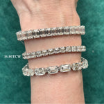 A hand wears three Asscher cut diamond tennis bracelets with varying cuts and sizes, including Asscher cut diamonds of VVS-VS clarity, on a green fabric background. White text reads "16.80 TCW" near the bracelets—all set in luminous 18k white gold. Product shown: Tab Set Asscher Cut Diamond Tennis Bracelet in White Gold.