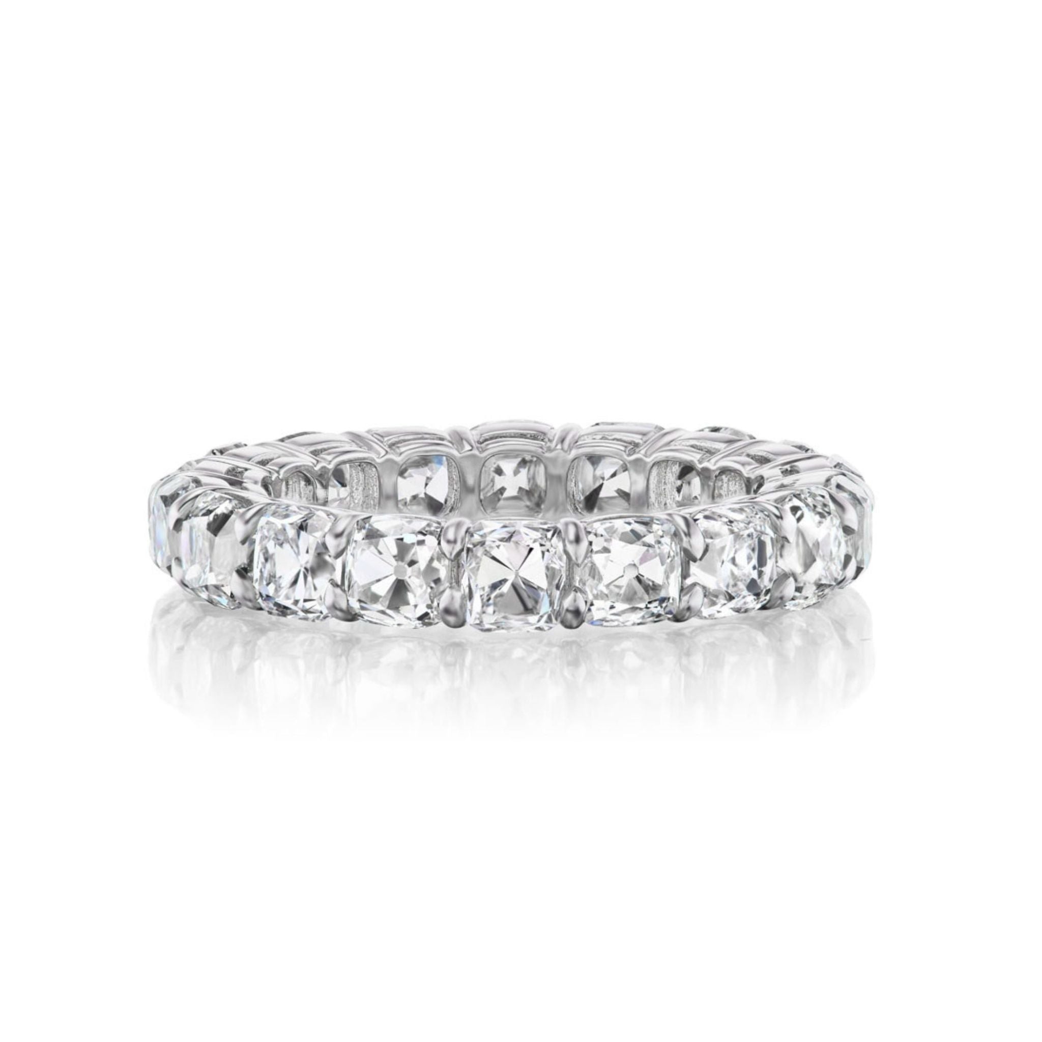 The Old Mine Cut Diamond Eternity Band showcases a continuous row of cushion-cut, old mine cut diamonds in white metal, displayed on a white background with a subtle reflection beneath.