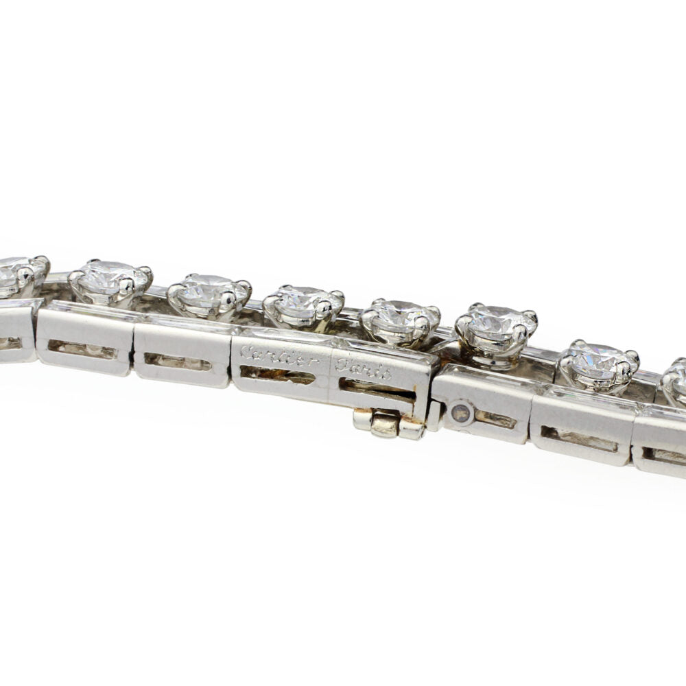 A close-up of the Cartier Mid-Century Diamond Bracelet, featuring round-cut clear gemstones in prong settings with a box clasp and safety latch, inspired by vintage designs. The background is white.