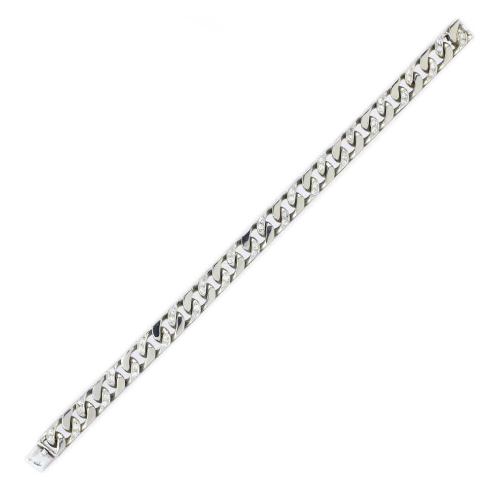 A Van Cleef & Arpels white gold and diamond bracelet featuring large, flat, interlocking links in a classic curb style, displayed laid out straight on a white background.