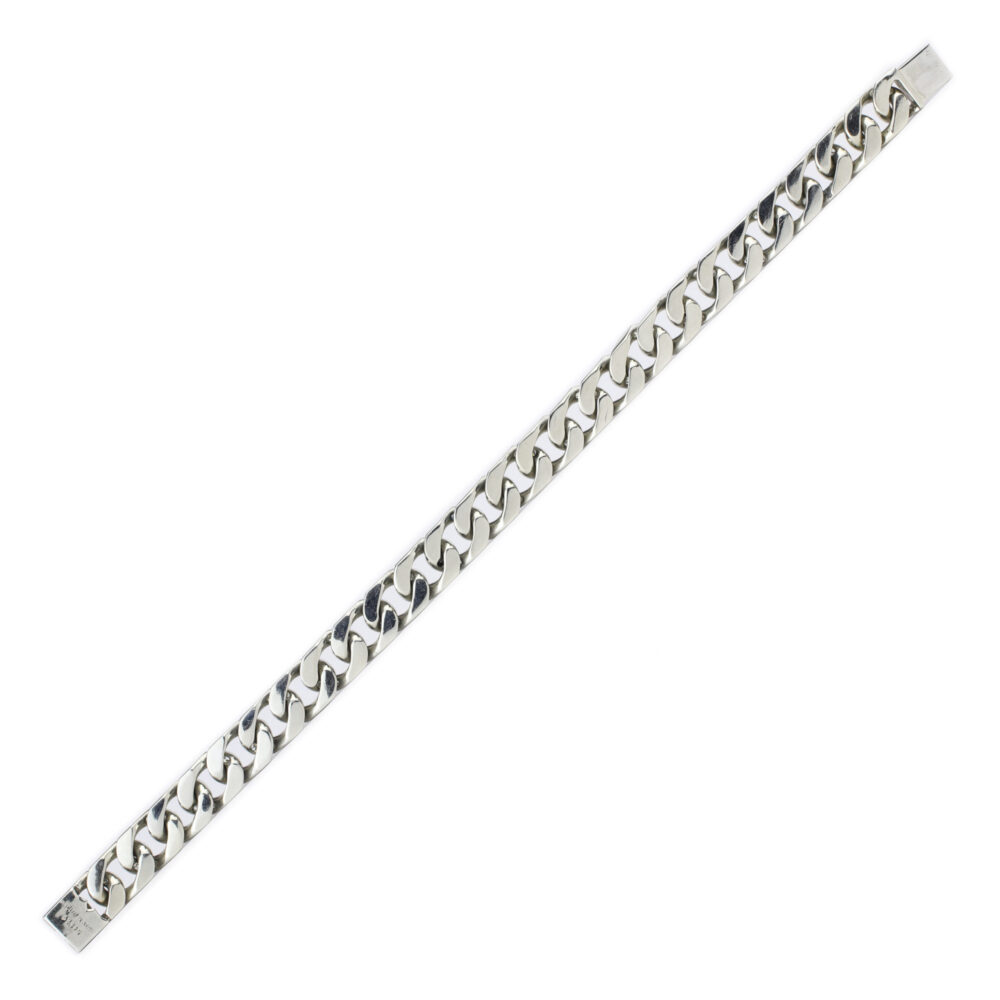 A Van Cleef & Arpels white gold and diamond bracelet with flat, wide, closely interlocked links is displayed diagonally on a white background, showcasing a sleek polished look inspired by vintage 1980s design.