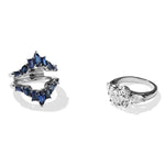 Two rings are shown on a white background: one is a Baguette and Marquise Sapphire Engagement Ring Jacket in White Gold with a unique split-band design; the other is a classic white gold engagement ring with three clear gemstones.