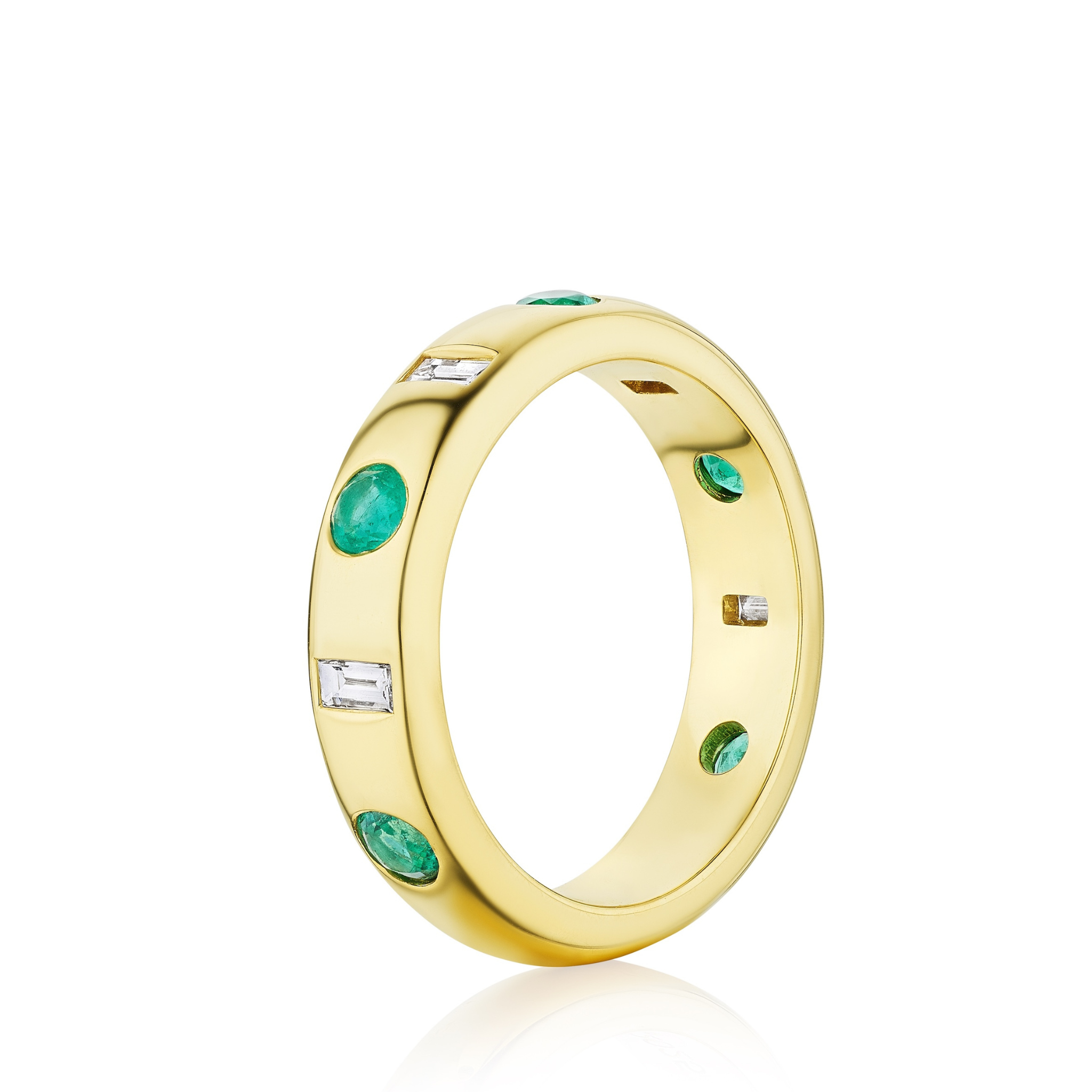 The Burnish Set Baguette Diamond and Round Emerald Band in Yellow Gold features oval green emeralds and rectangular clear diamonds, evenly spaced around a yellow gold band, displayed on a white background.