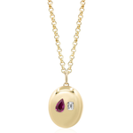The Burnish Set Pear Shape Ruby and Emerald Cut Diamond in Yellow Gold features a yellow gold pendant with an oval surface set with a teardrop-shaped ruby and a rectangular emerald cut diamond.