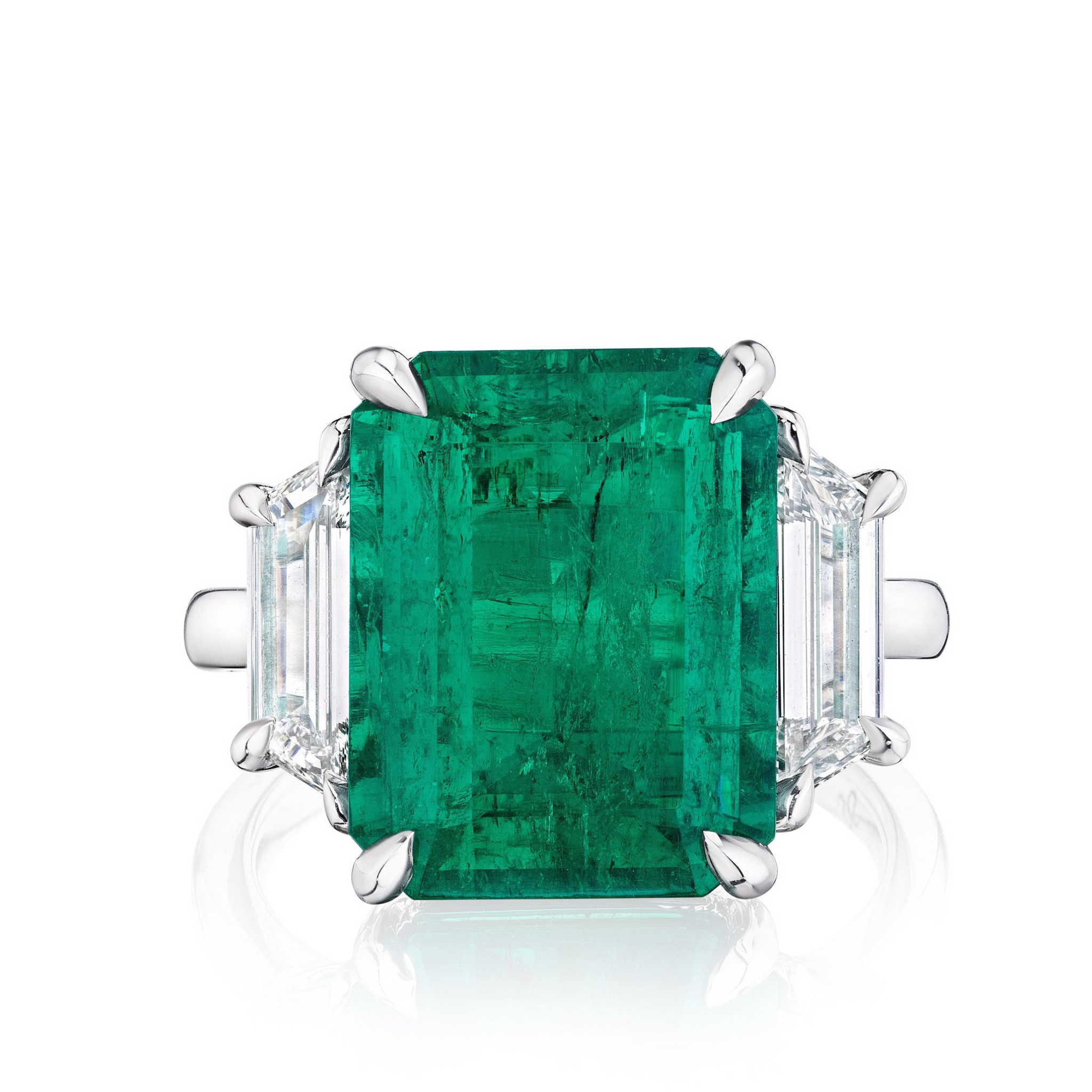 The Bespoke Emerald Cut Colombian Emerald Engagement Ring in white gold showcases a large emerald center stone and trapezoid baguette side stones, displayed on a white background.