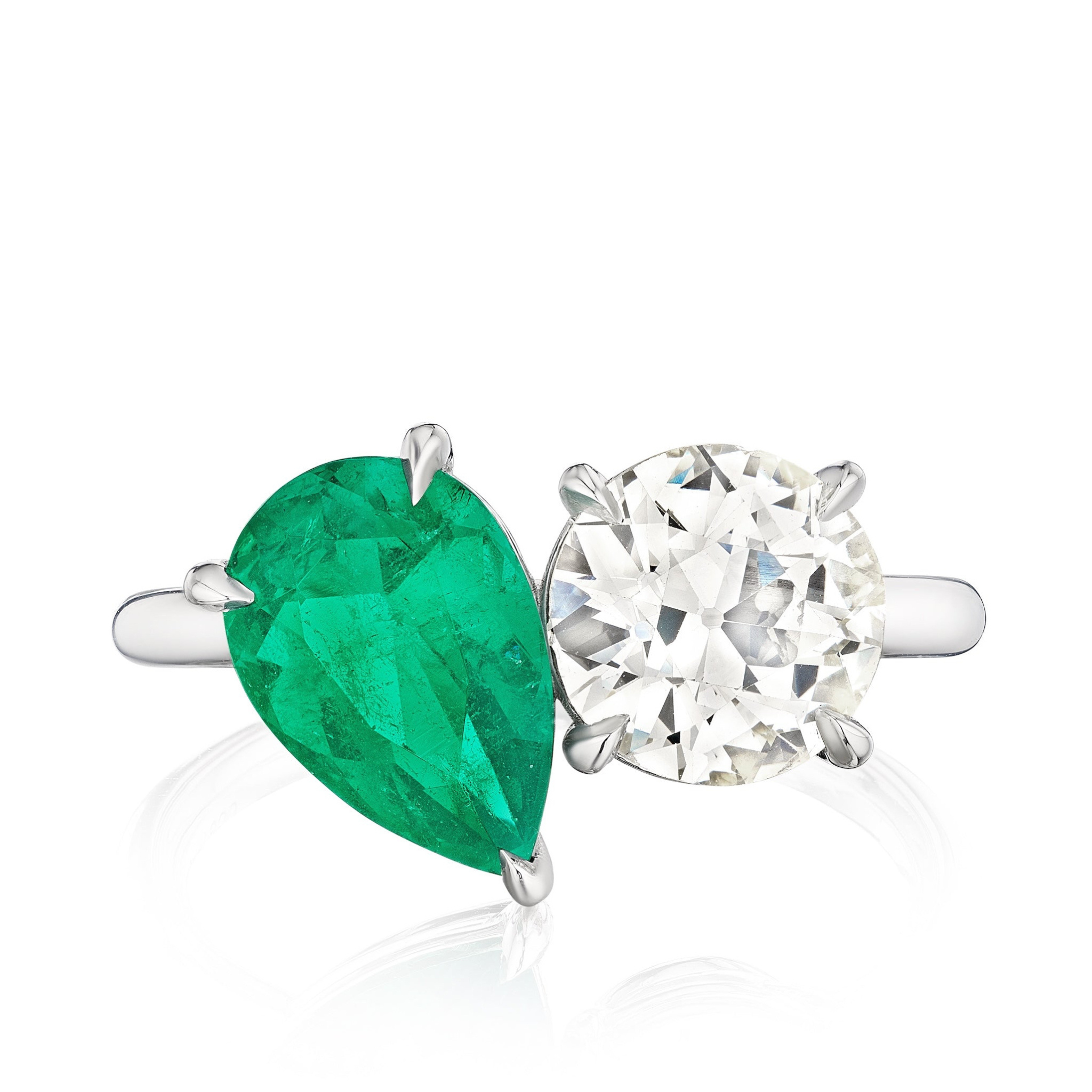 The Bespoke Toi et Moi Pear Shape Emerald and Round Diamond Engagement Ring in White Gold features a pear emerald and round diamond side by side on a sleek white gold band, shown against a white background.