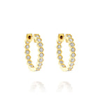 Bezel Set Hexagon Huggies with Round Brilliant Diamonds feature a modern hexagonal gold design with each section set with a round diamond, offering elegant 18K gold huggie earrings displayed on a white background.