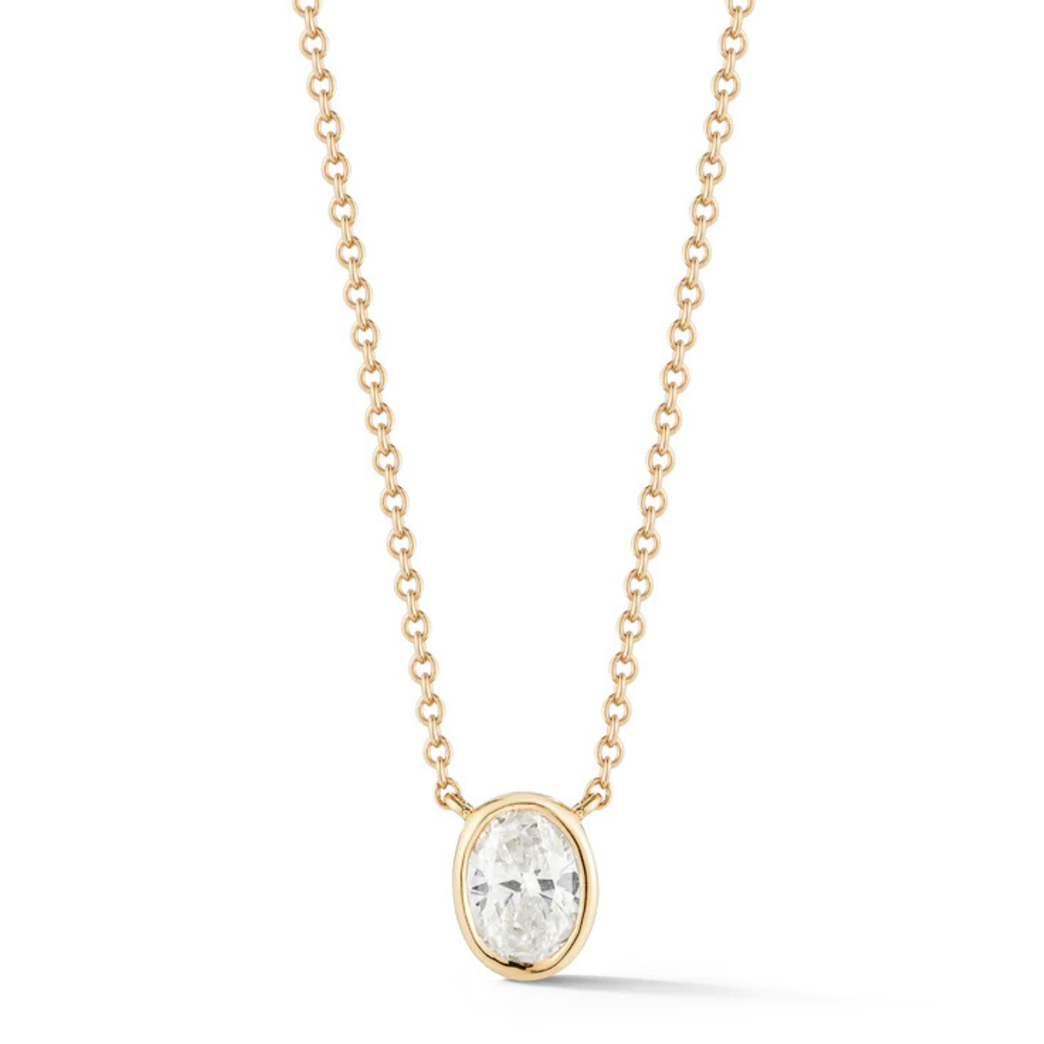 The Bezel Set Oval Diamond Solitaire Pendant in Yellow Gold features a delicate 18K yellow gold chain and an oval diamond in a simple bezel, plus an adjustable chain for versatile styling.