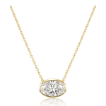 The East-West Bezel Set Oval Shape Diamond Pendant Necklace in Yellow Gold features an oval diamond bezel set on a delicate 18k yellow gold chain, creating an elegant centerpiece.