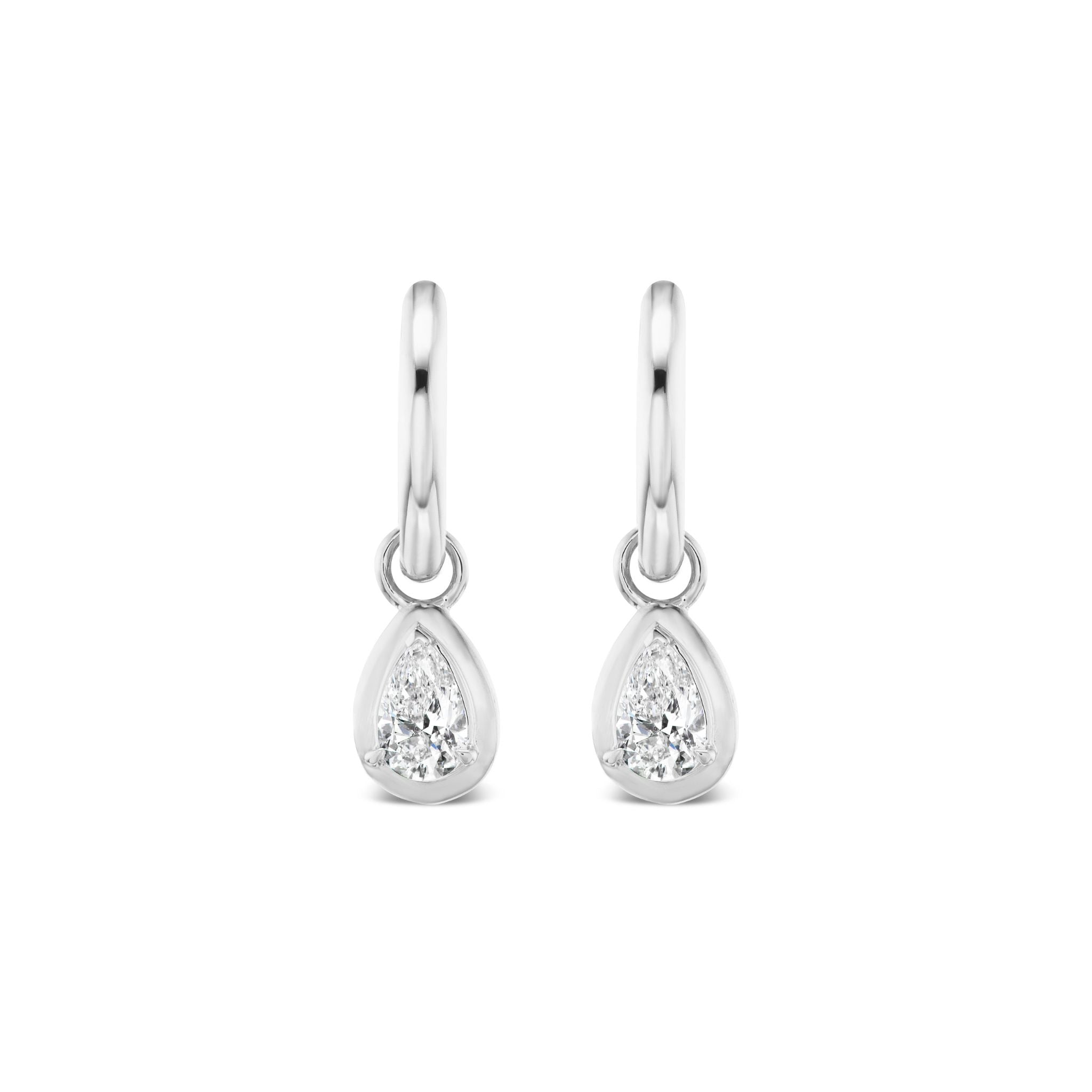 The Bezel Set Pear Shape Diamond Drop Earrings in White Gold feature 18k white gold hoops, each with a small, bezel-set pear-shaped diamond pendant for a simple and elegant design.