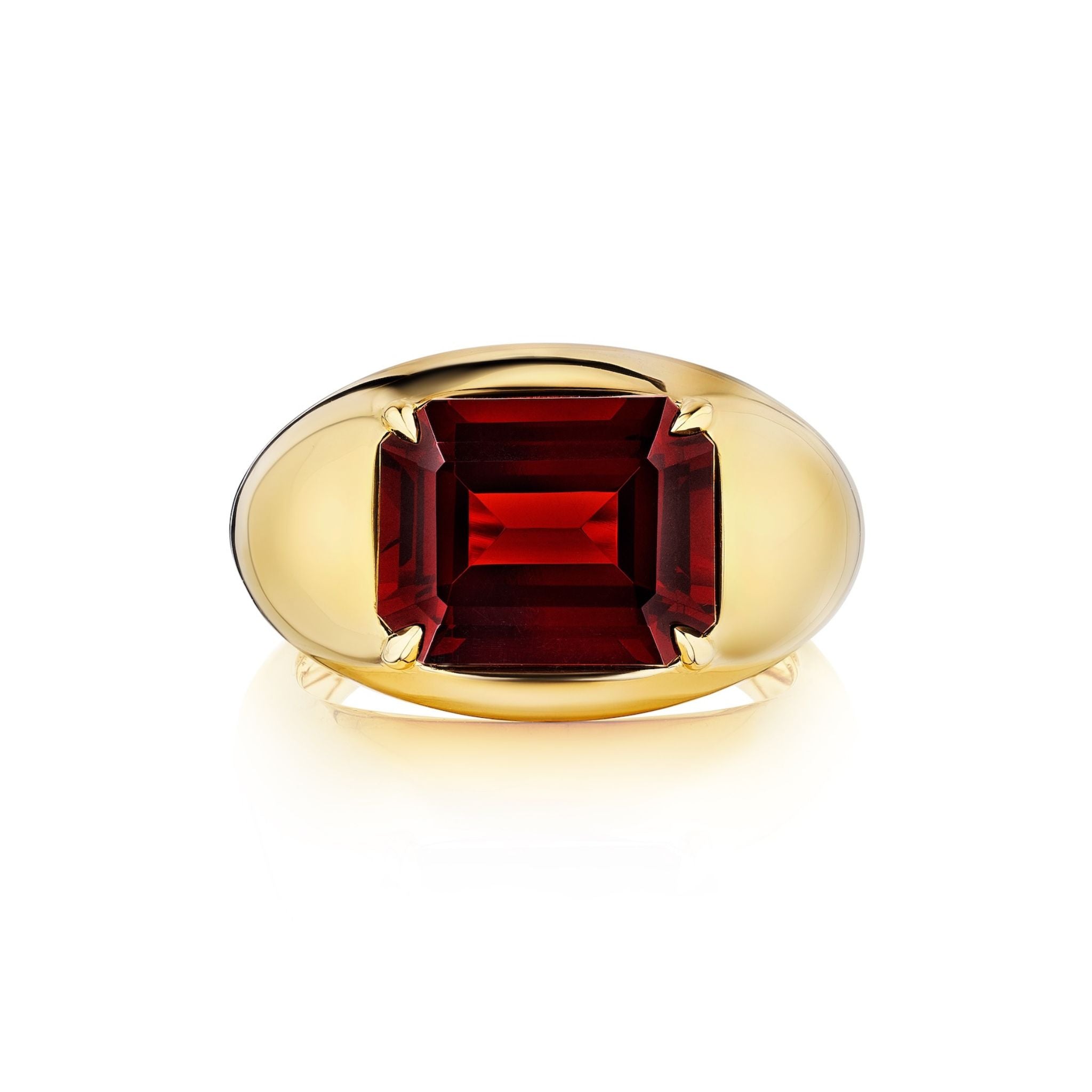 The Bombé Ring features an east-west set emerald cut ruby in yellow gold, highlighted by a polished band and classic prong setting, shown against a white background.