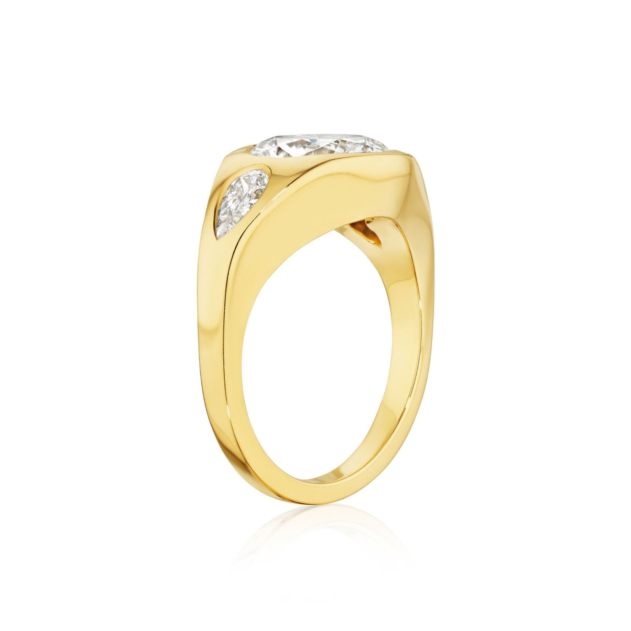 Showcased from a side angle against a white background, the Burnish Set Gypsy Ring with Round and Pear Shape Diamonds in Yellow Gold features a striking design with a large central diamond accented by smaller diamonds on each side—a stunning Serpentine Jewels creation.