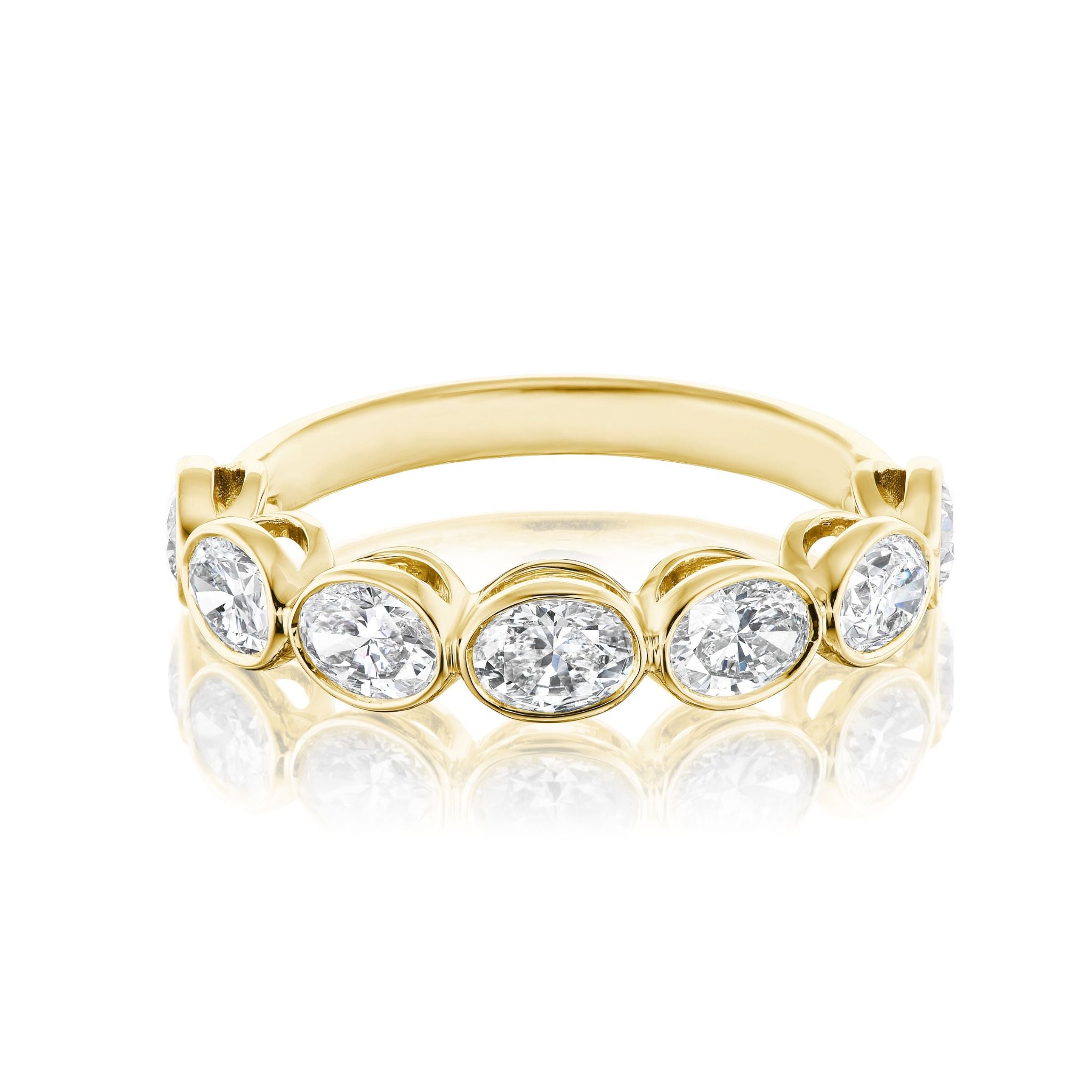 The Chasing Ovals Bezel Set Diamond Half Eternity Band features seven oval-cut white diamonds in individual bezels with a polished, reflective finish—an elegant choice for bridal rings.