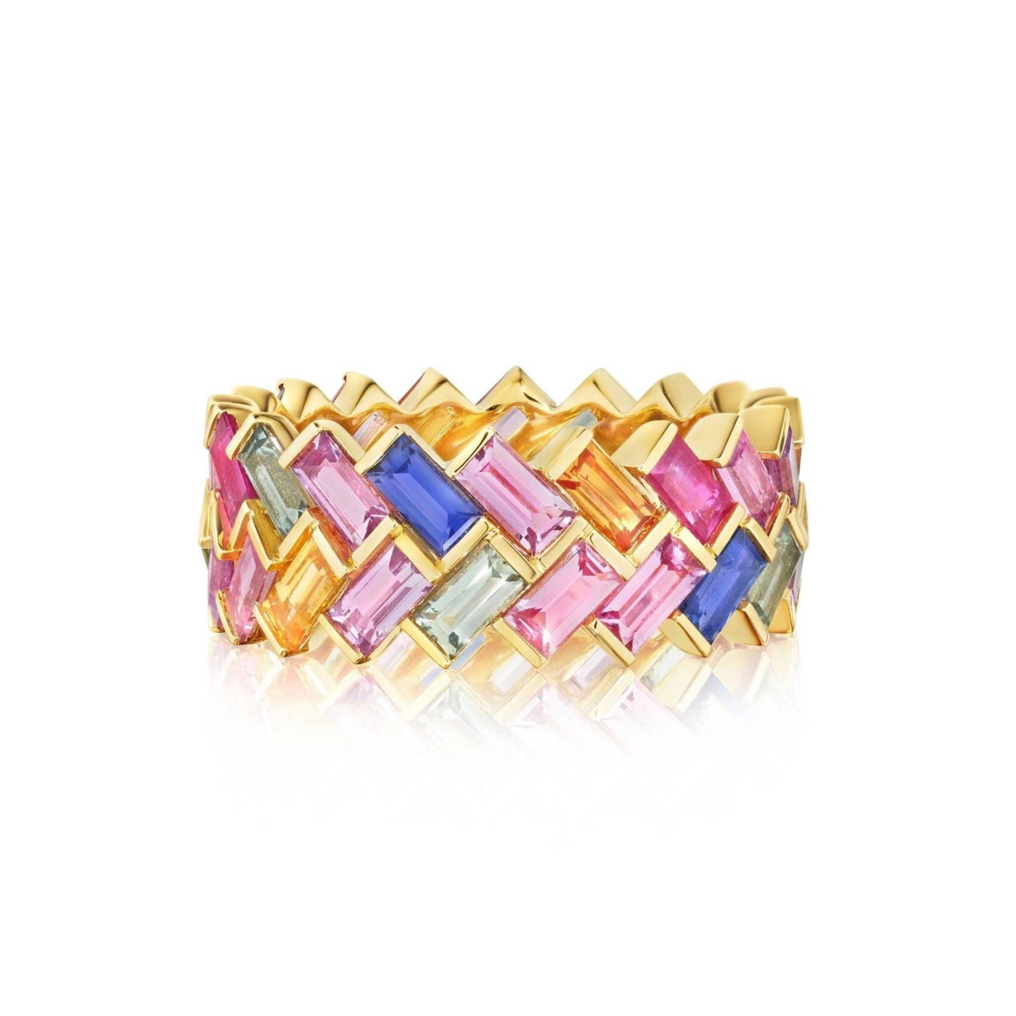 The Chroma Chevron Bezel Set Ring in 18K yellow gold features pink, orange, blue, green, and clear baguette sapphires arranged in a vibrant woven chevron pattern.