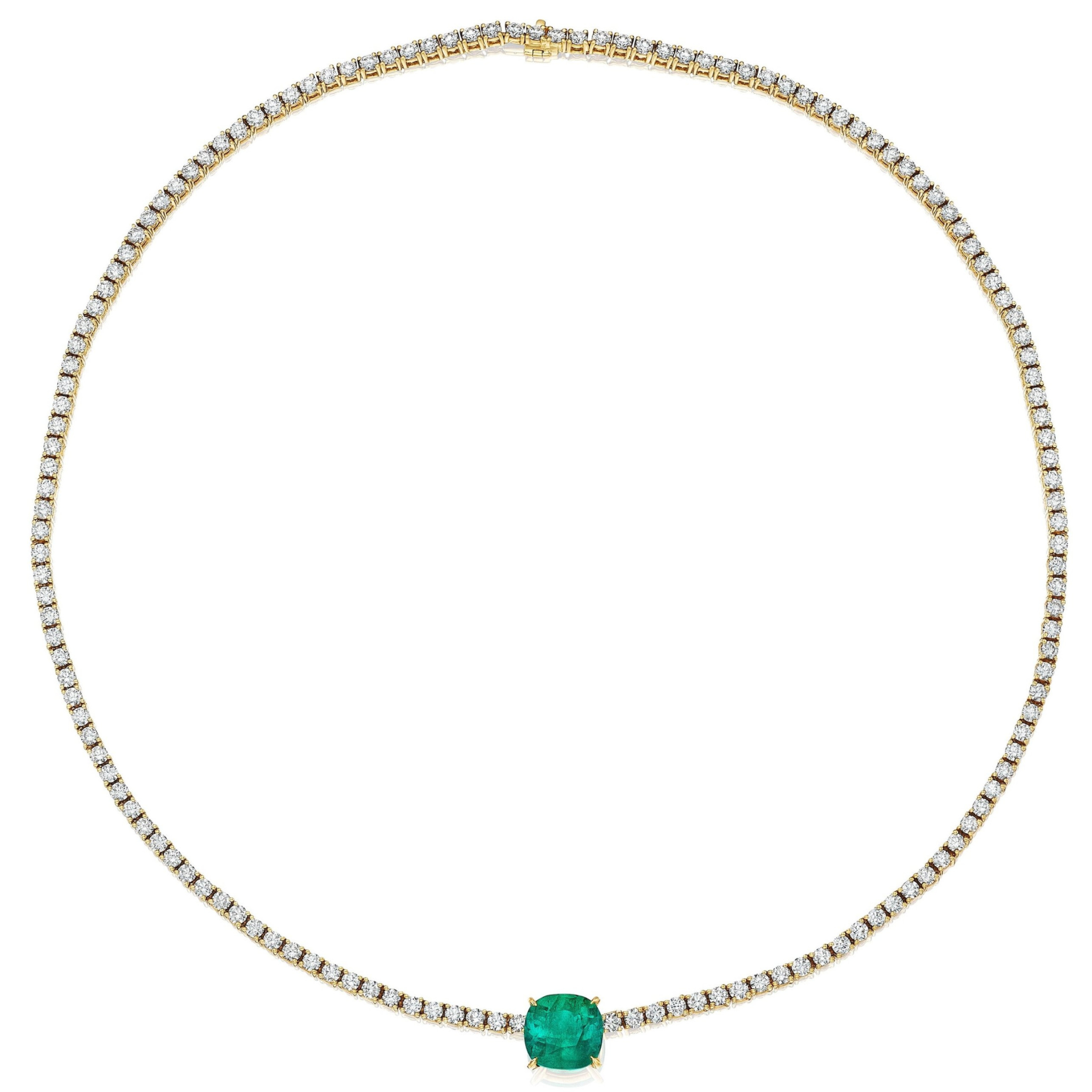 The Classic Tennis Necklace with Cushion Cut Emerald in Yellow Gold features a delicate line of small white diamonds and a prominent cushion-cut Colombian emerald centerpiece, all crafted in 18K yellow gold.