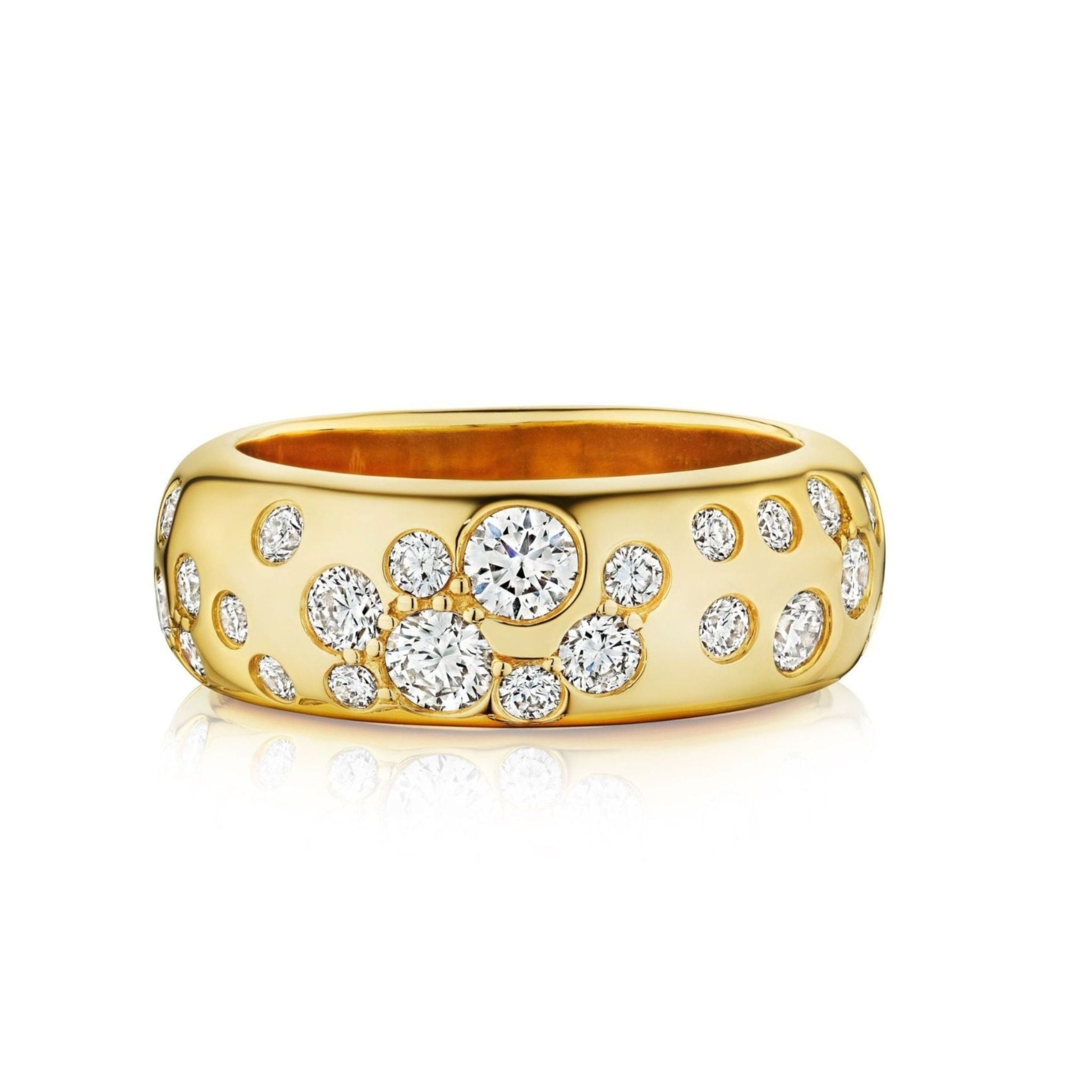 The Cluster Cigar Band features a wide 18K yellow gold design with burnish set round brilliant diamonds in varying sizes, creating a scattered cluster pattern across its smooth surface.