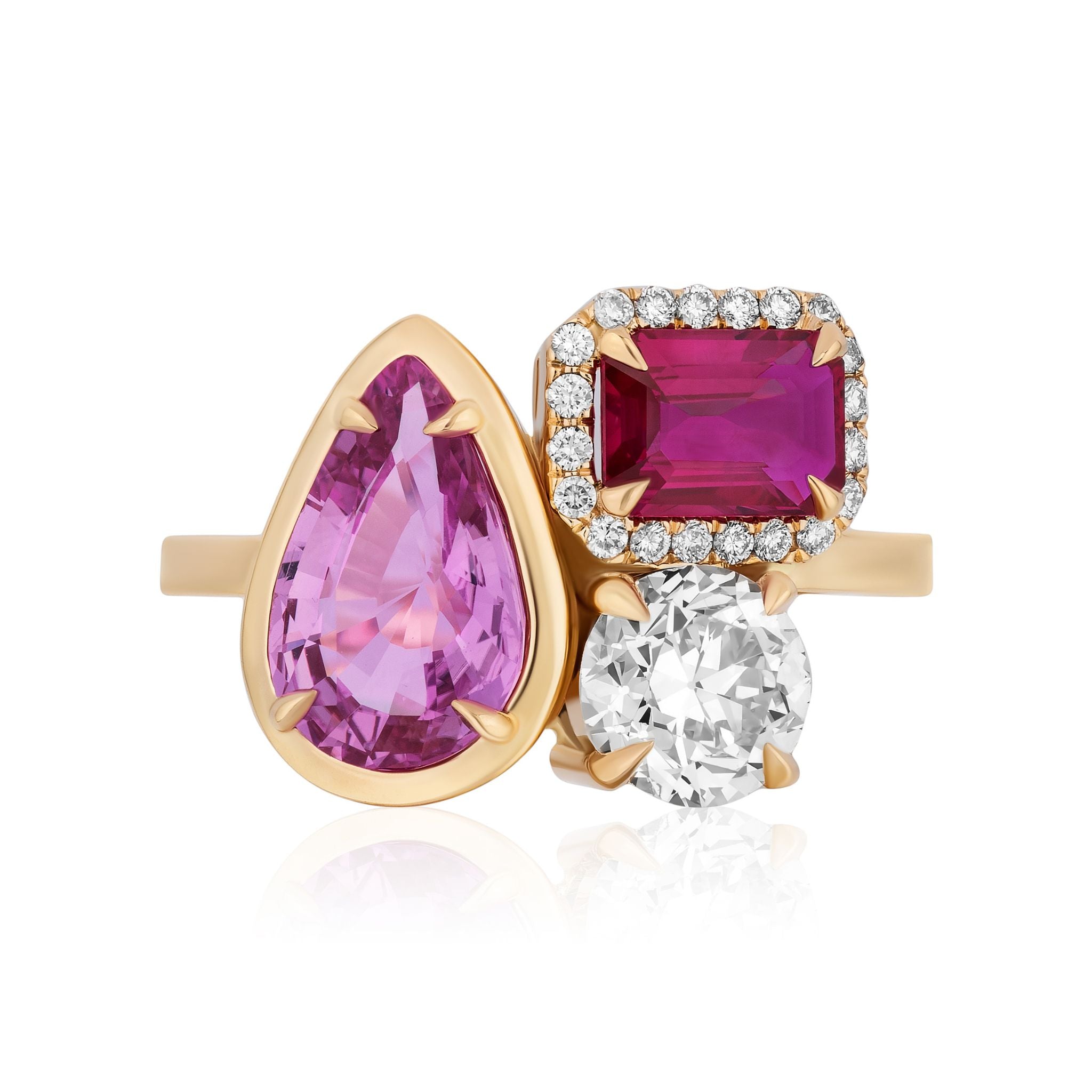 A striking yellow gold cluster ring with a bezel-set pear-shaped sapphire, pavé emerald-cut sapphires, and a round diamond.