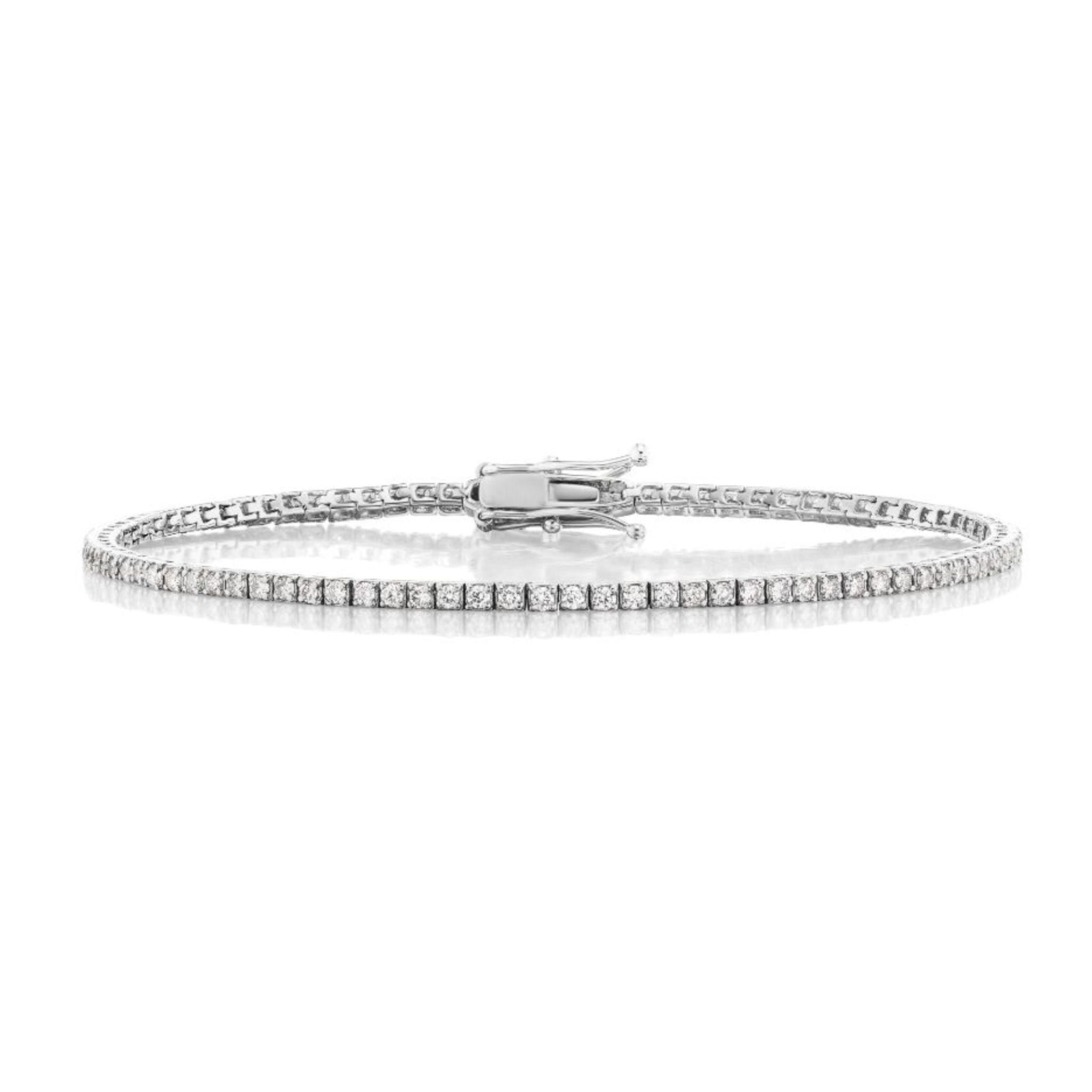 Introducing the Skinny Round Brilliant Diamond Tennis Bracelet: a delicate white gold bracelet featuring a single row of round brilliant diamonds, secured with a reliable clasp and elegantly displayed on a pristine white background.