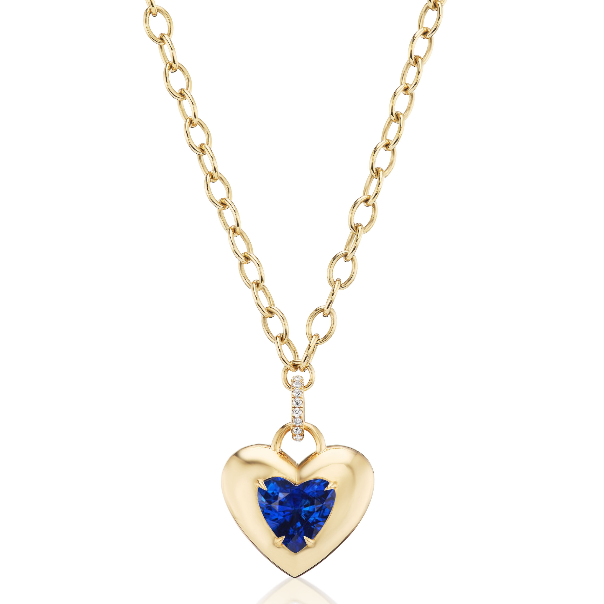 The Collet Set Heart Shape Blue Sapphire Pendant in Yellow Gold features a heart-shaped blue sapphire centerpiece on an 18K yellow gold chain, accented with small clear stones on the pendant bail.