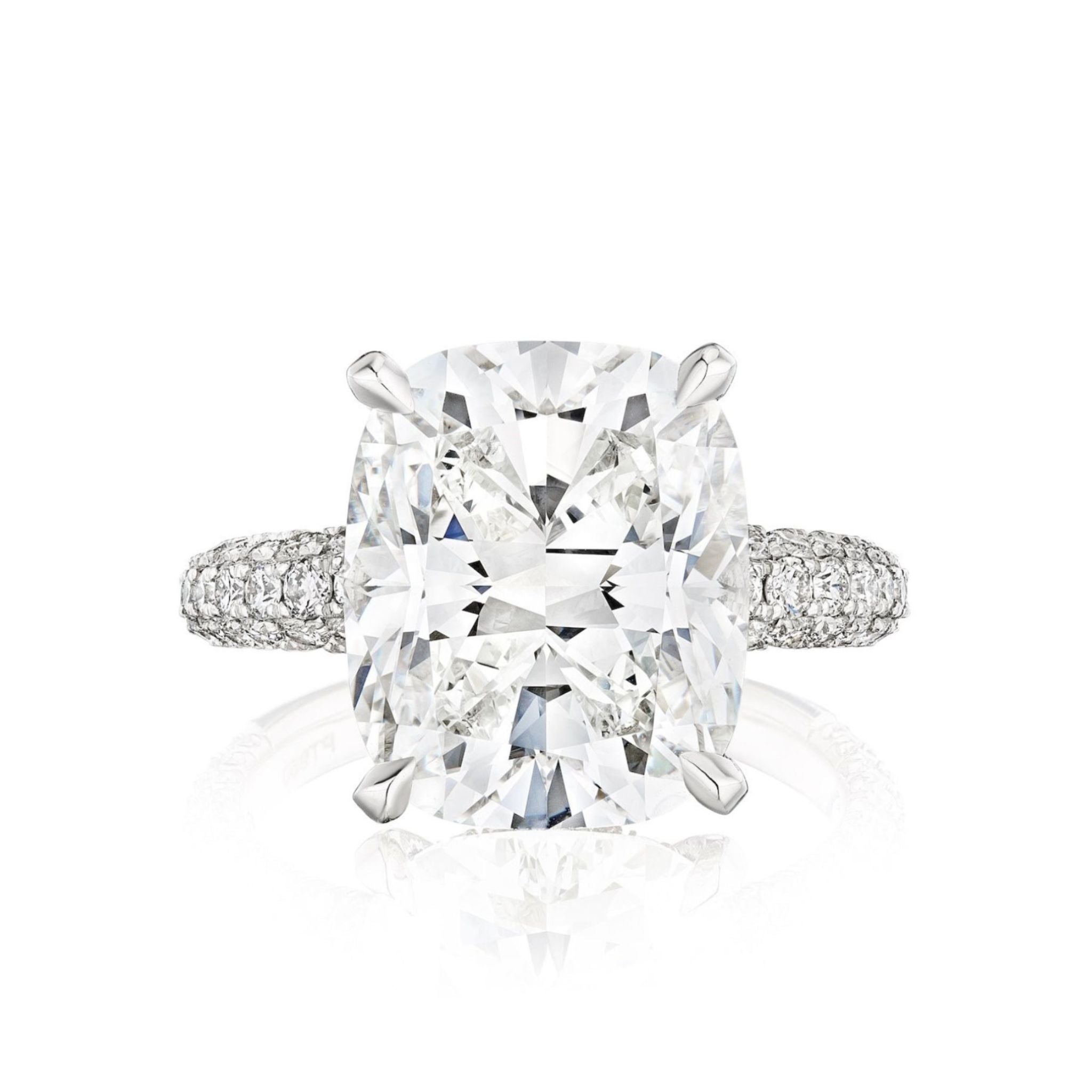 The Cushion Cut Diamond Engagement Ring with Pavé Band features a large center stone in four prongs and a pavé band of small round diamonds, showcased against a white background.