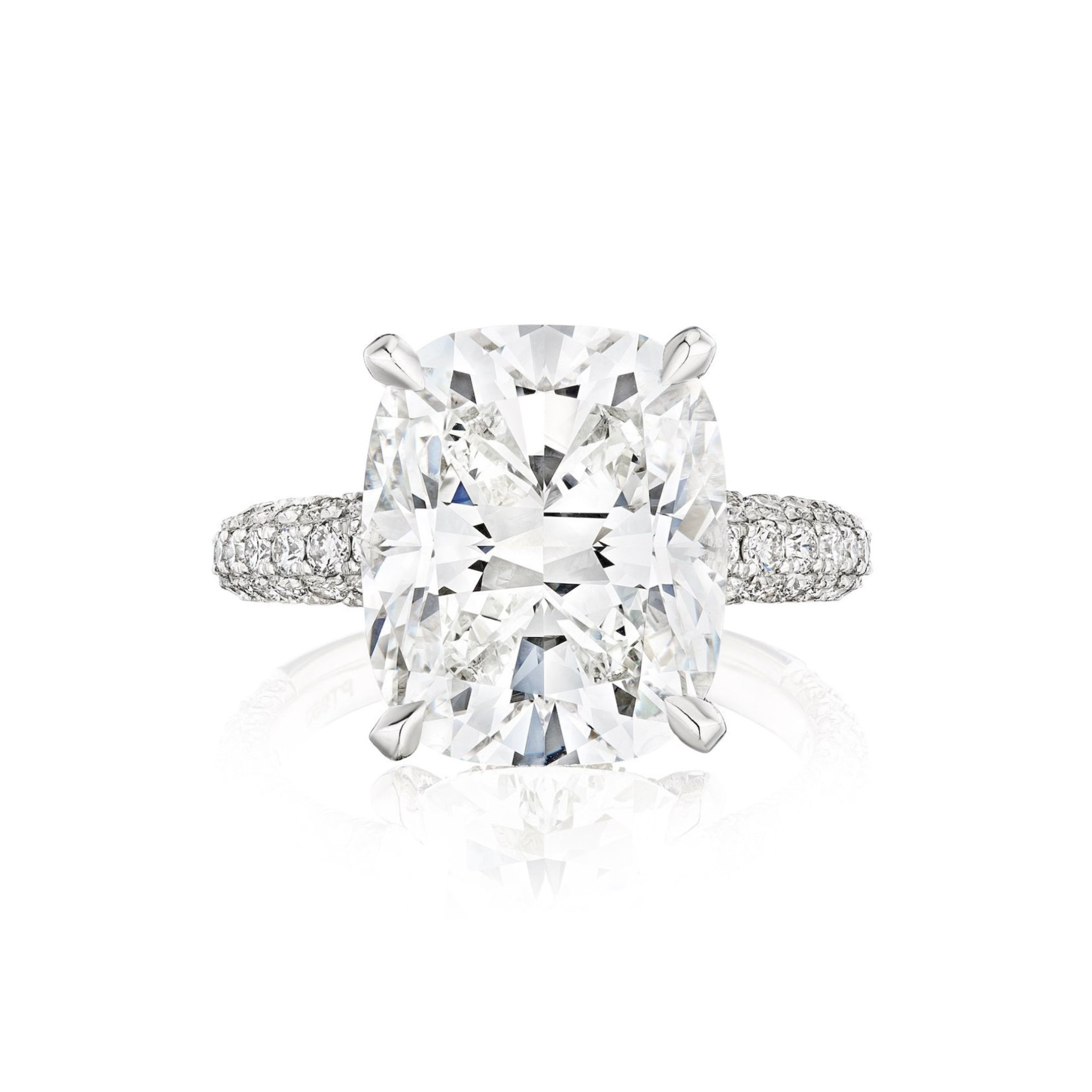 The Cushion Cut Diamond Engagement Ring with Pavé Band features a large cushion-cut center stone in four prongs, set on a brilliant multi-tier pavé band adorned with round diamonds, shown against a white background.