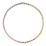 The Chroma Match Point Multicolor Tennis Necklace in Yellow Gold showcases marquise sapphires in a dazzling rainbow gradient—ranging from pink, red, orange, yellow, green to blue—arranged in a continuous loop. Round diamonds accent this necklace for added brilliance.