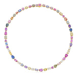 The Chroma Kaleidoscope Mixed Shape Sapphire and Diamond Tennis Necklace in Yellow Gold showcases a continuous serpentine loop of sapphires in pink, blue, yellow, and purple hues—each gemstone varying in shape and size—beautifully set alongside sparkling diamonds.