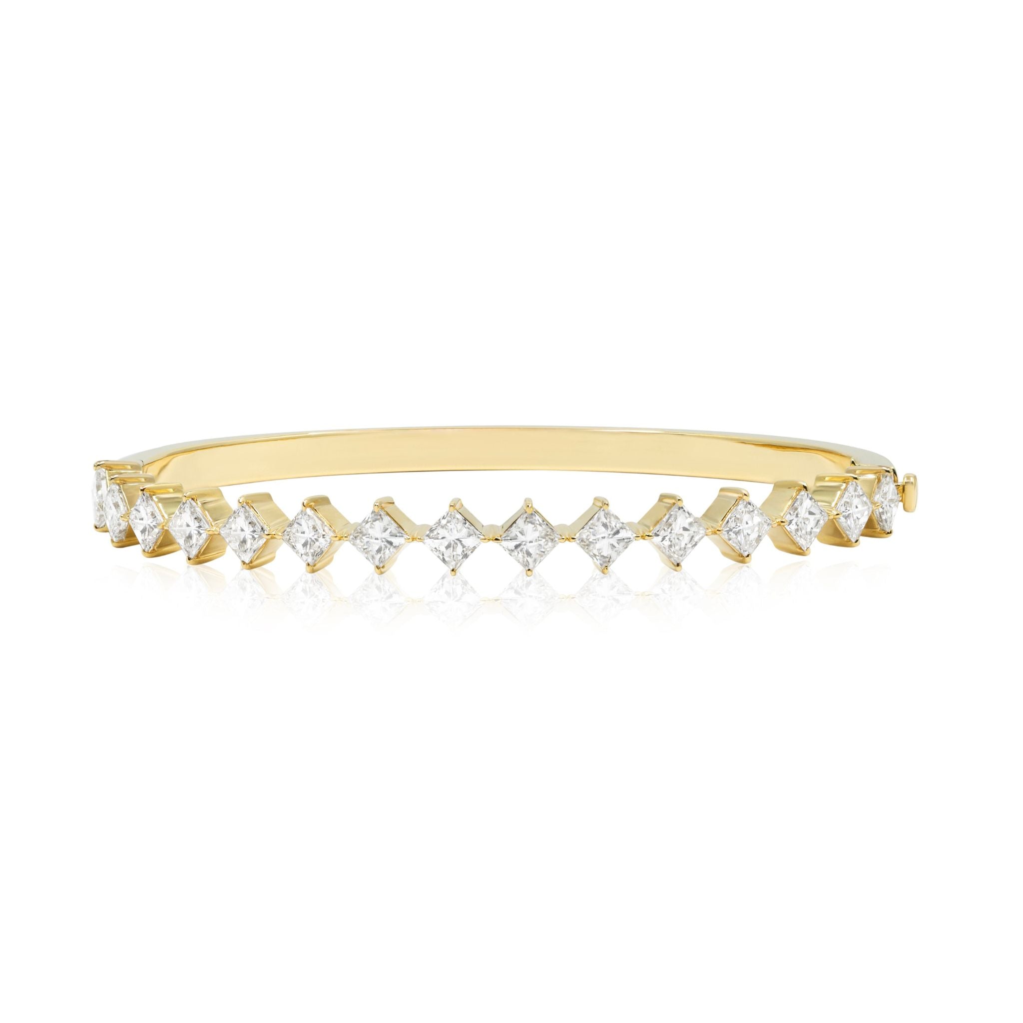 The Diagonally Set Square Diamond Bangle in Yellow Gold features a sleek polished 18k yellow gold band, adorned with square-cut diamonds set in a zigzag across the top and secured by a side clasp.