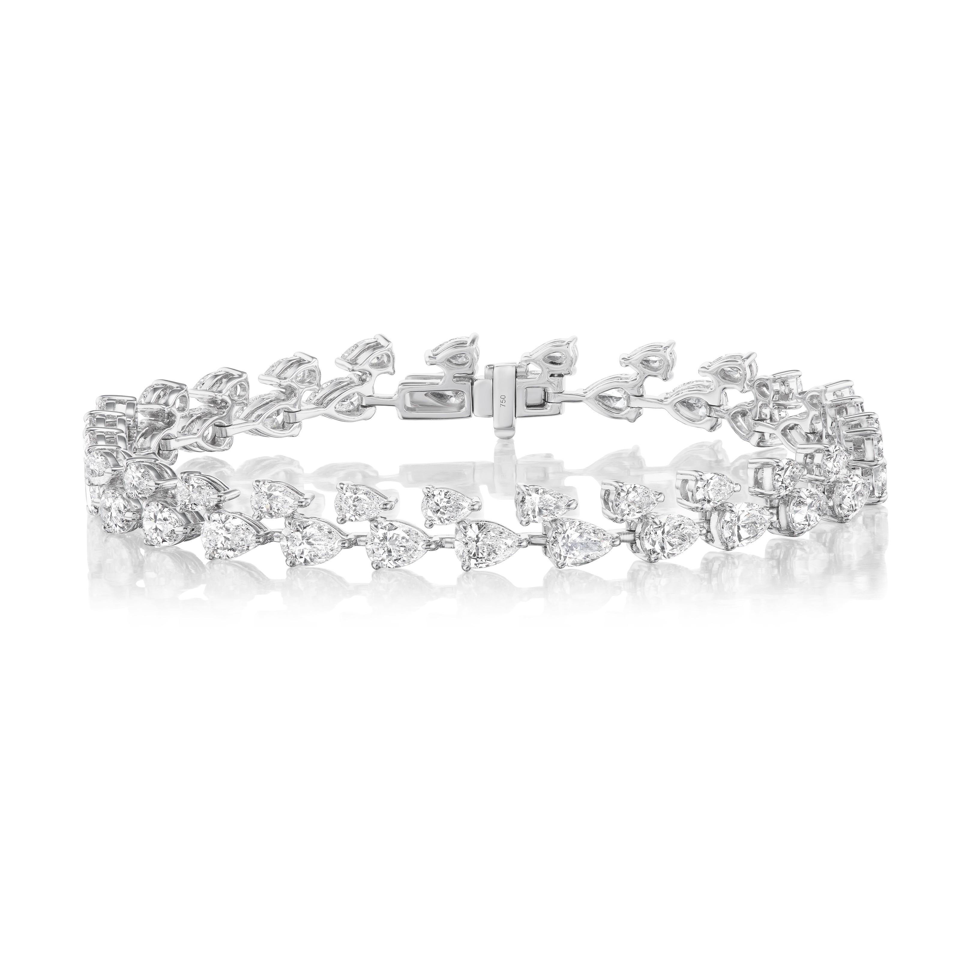 The Duo Pear Diamond Tennis Bracelet in White Gold showcases two rows of sparkling pear-shaped diamonds in a repeating pattern, secured with a central clasp and elegantly displayed against a white background.