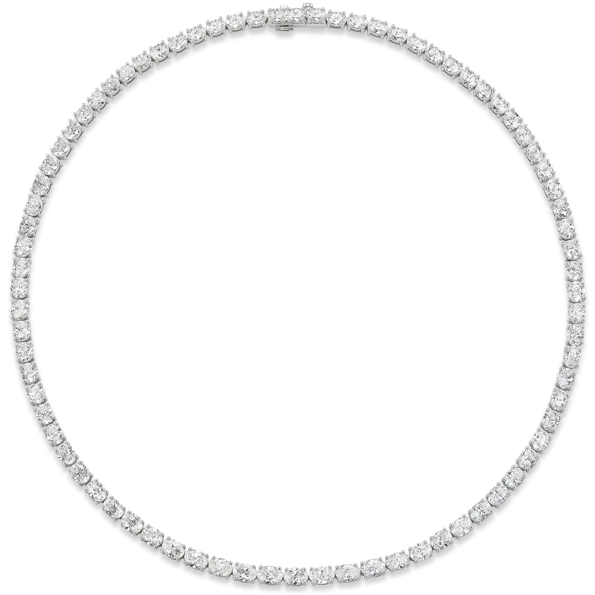 The East-West Oval Diamond Tennis Necklace in White Gold features dazzling F-G color oval diamonds set closely together in a continuous line, exquisitely displayed against a white background.