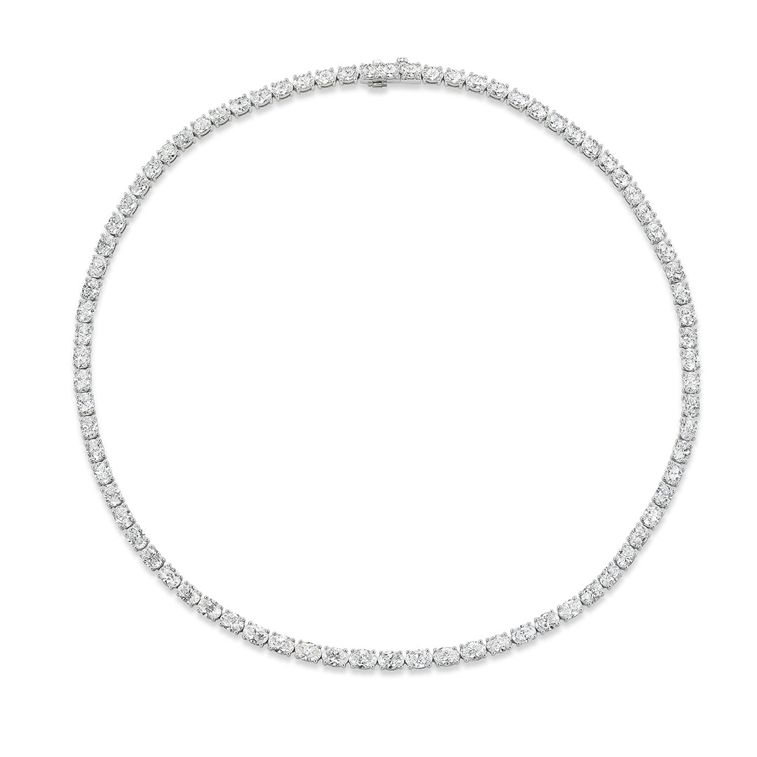 The Graduated East-West Oval Diamond Tennis Necklace in white gold features a continuous row of oval diamonds, elegantly set and displayed against a plain white background.