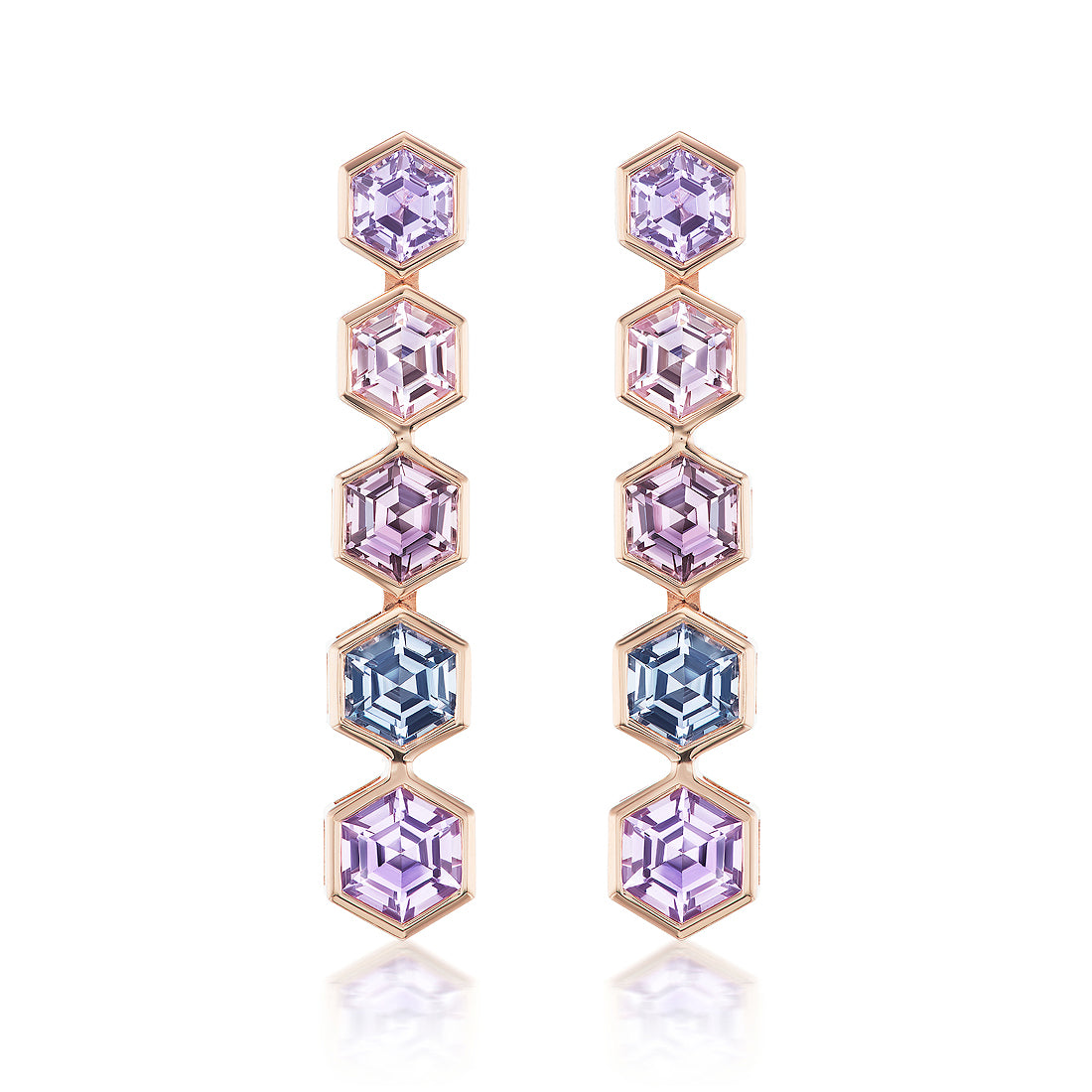 The Spectrum Drop Earrings feature five vertically arranged hexagonal, multicolor sapphires bezel set in gold, showcasing purple and blue hues against a white background.