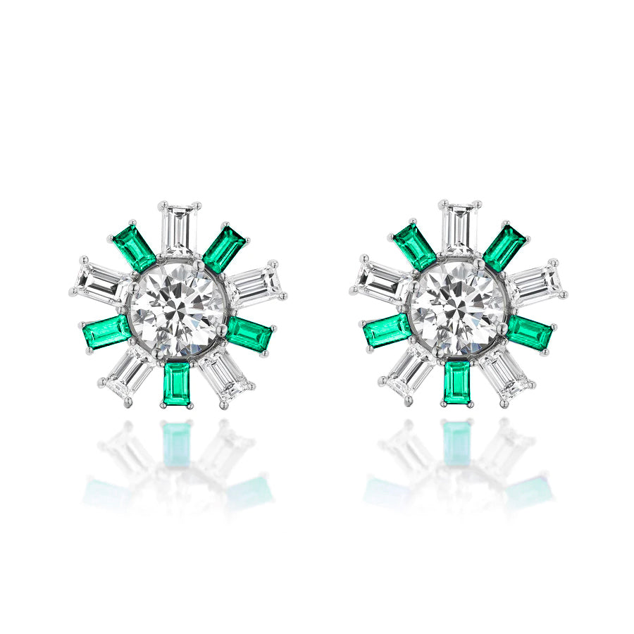 The Confetti Ear Jackets in white gold feature emerald cut diamonds and emeralds in a sunburst design, accented by a central gemstone for a sparkling statement look.