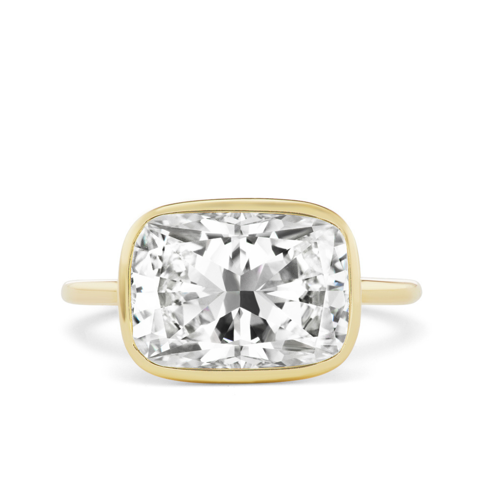 The East-West Bezel Set Cushion Cut Diamond Engagement Ring features a large cushion-cut diamond in a simple bezel setting, showcased against a white background.