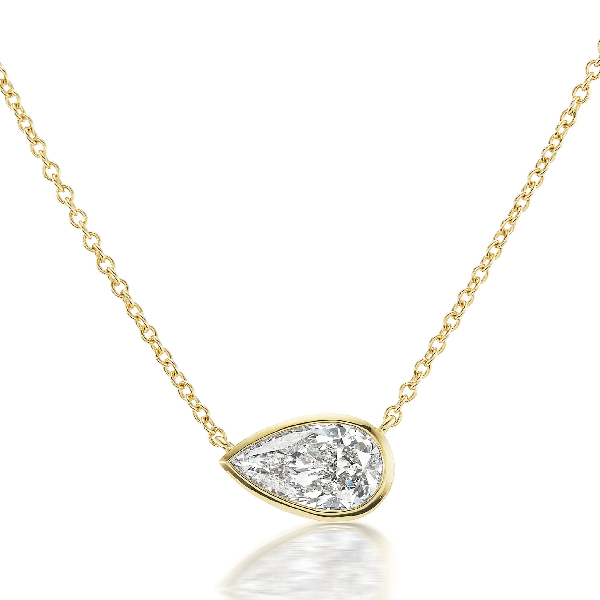 The East-West Bezel Set Pear Diamond Pendant in Yellow Gold features a delicate 16-inch gold chain and an 18K yellow gold bezel setting with a pear-shaped diamond oriented horizontally.