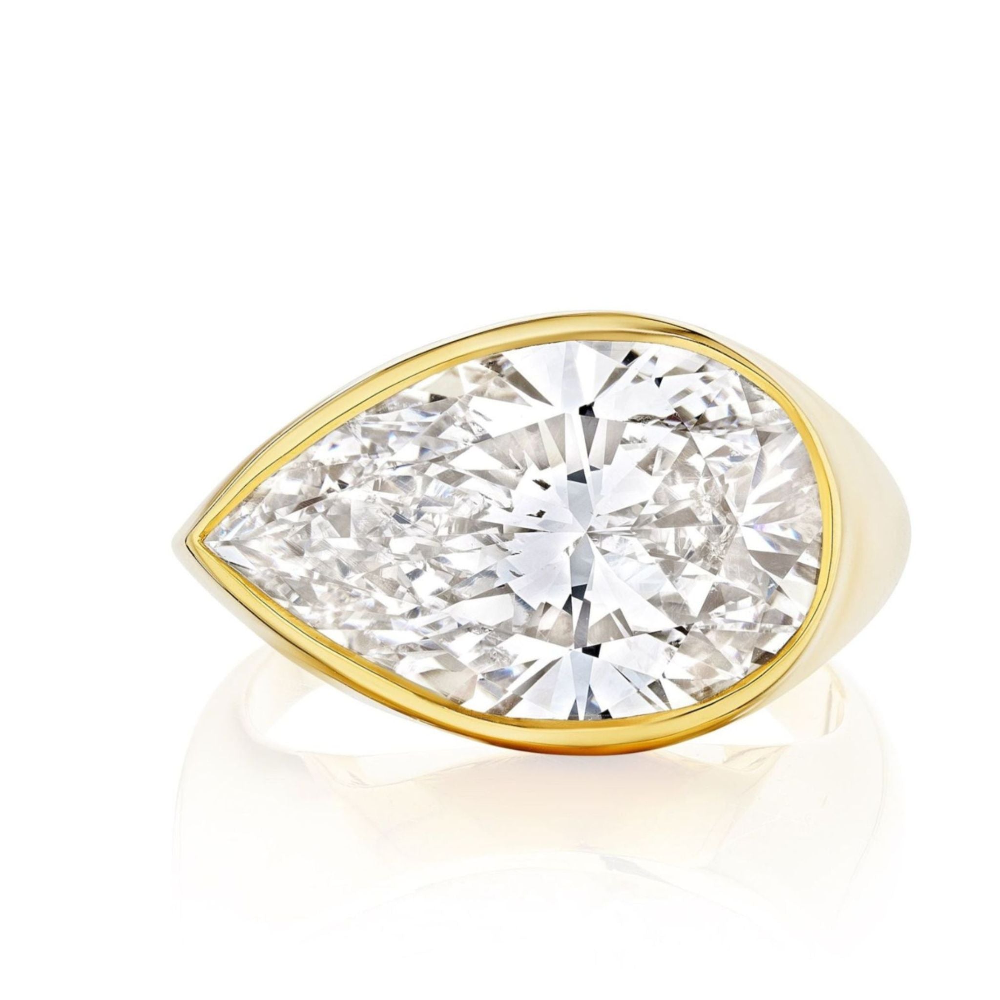 The East-West Bezel Set Pear Shape Diamond Ring in Yellow Gold showcases a large pear-shaped diamond in a sleek, elegant bezel setting.