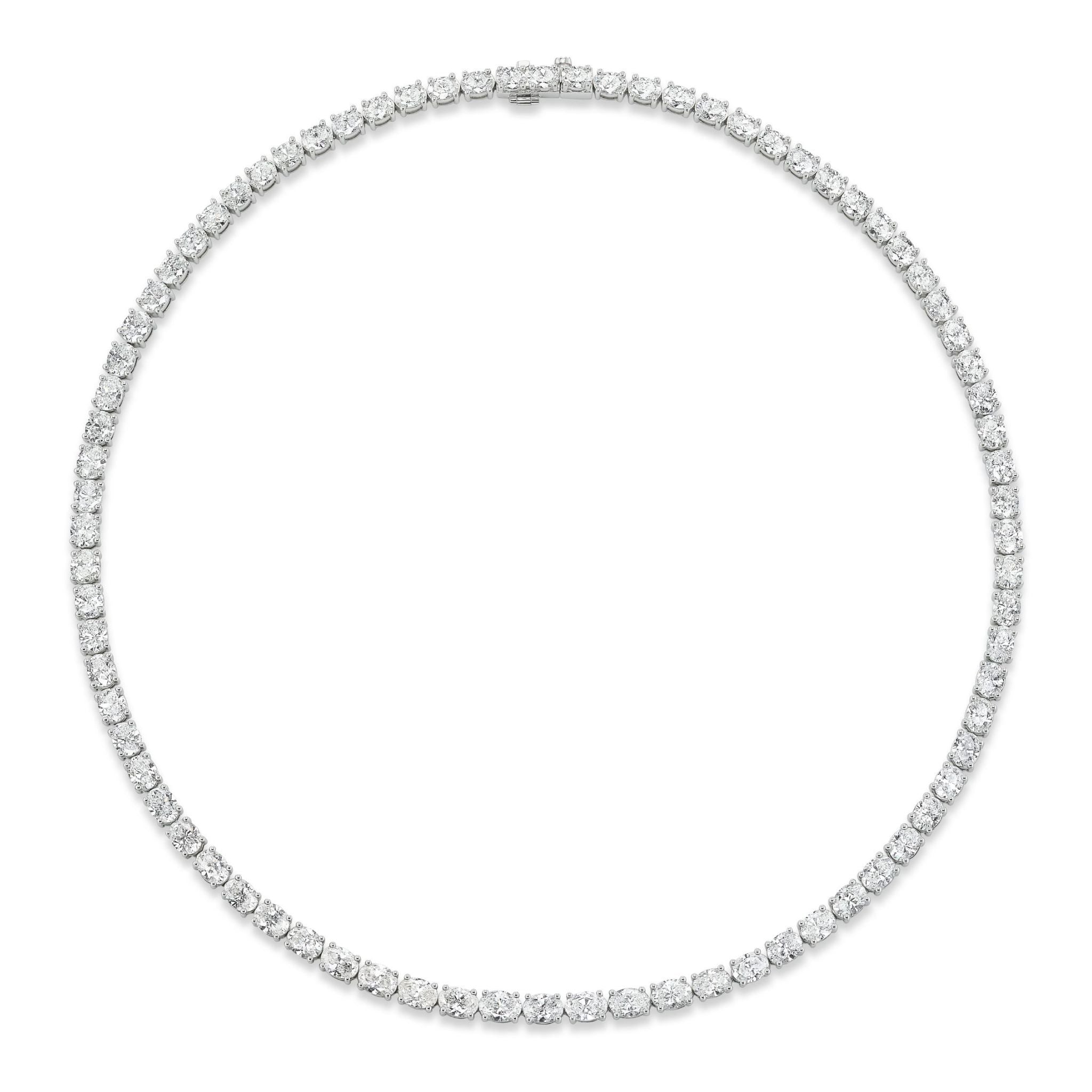 The East-West Oval Diamond Tennis Necklace in White Gold features evenly spaced, sparkling oval diamonds set horizontally in a continuous line on a lustrous 18K white gold chain, forming a full circle and measuring 16 inches in length.