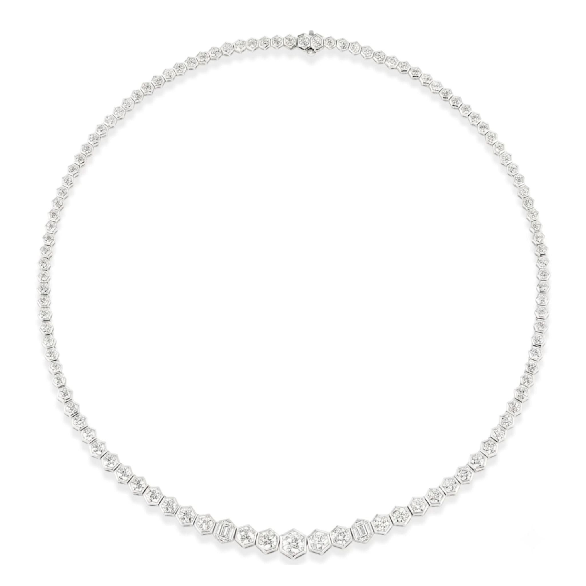 The Graduated Hexagon Bezel Set Round Diamond Tennis Necklace in White Gold showcases round brilliant cut diamonds elegantly set within graduated hexagon-shaped bezels, forming a continuous and sophisticated design. Expertly crafted in 18k white gold, this exquisite necklace measures 16 inches for a graceful fit around the neck.