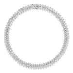 Bezel Set Chevron Diamond Tennis Necklace in White Gold features overlapping baguette-cut diamonds set in a striking chevron pattern, creating a seamless circular chain against a white backdrop. Expertly crafted from luxurious 18K white gold, each hand-selected baguette diamond boasts VVS1-VS1 clarity for exceptional brilliance and refined elegance.