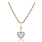 The Collet Set Heart Shape Diamond Necklace in Black Rhodium and Yellow Gold features a heart-shaped diamond pendant with a large, clear gemstone set in an elegant silver frame, beautifully accented by 18k yellow gold details.