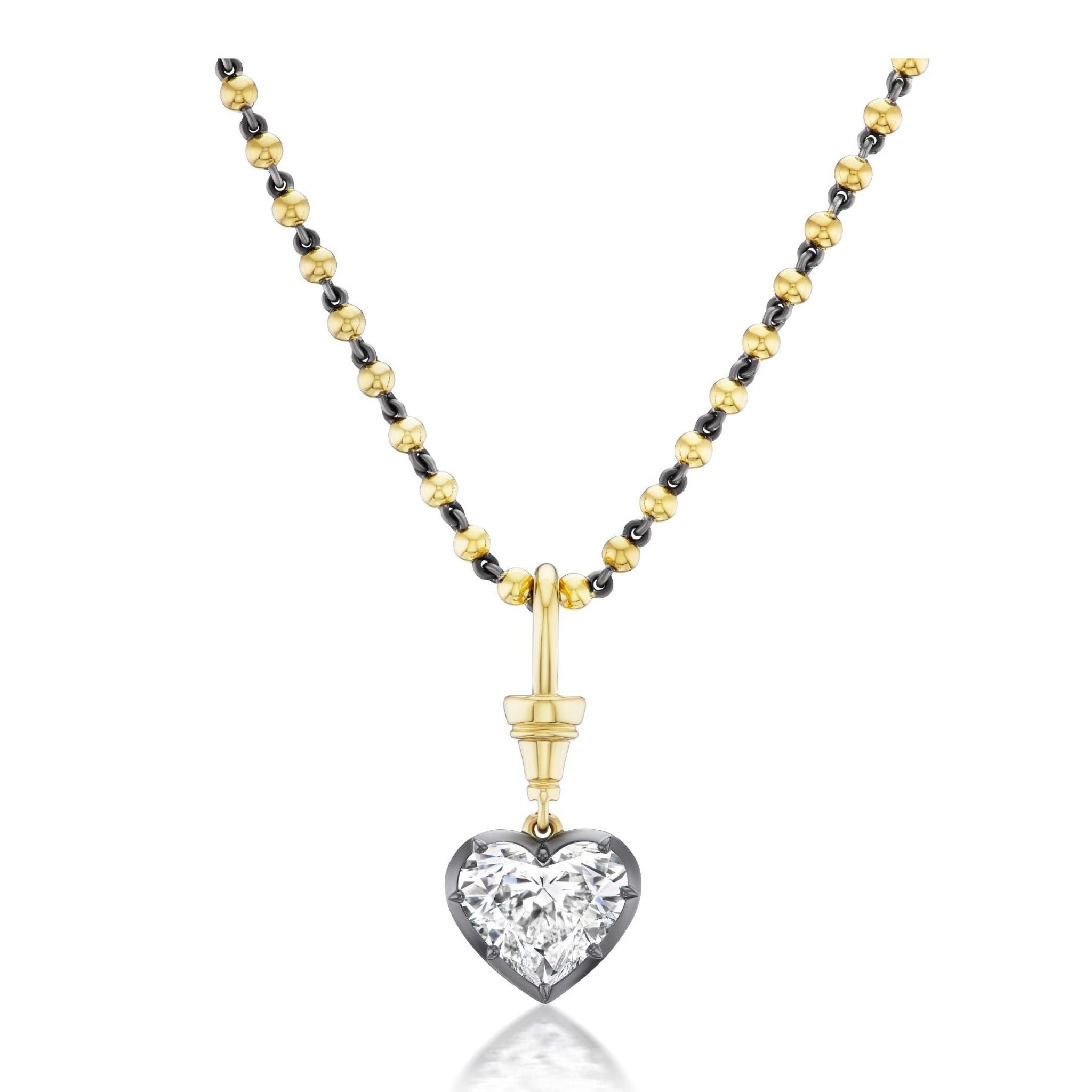 The Collet Set Heart Shape Diamond Necklace in Black Rhodium and Yellow Gold features a heart-shaped diamond pendant with a large, clear gemstone set in an elegant silver frame, beautifully accented by 18k yellow gold details.