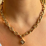 A person wears the Chain Necklace with Diagonal Bezel Set Elongated Square Diamond Charm in Yellow Gold around their neck.