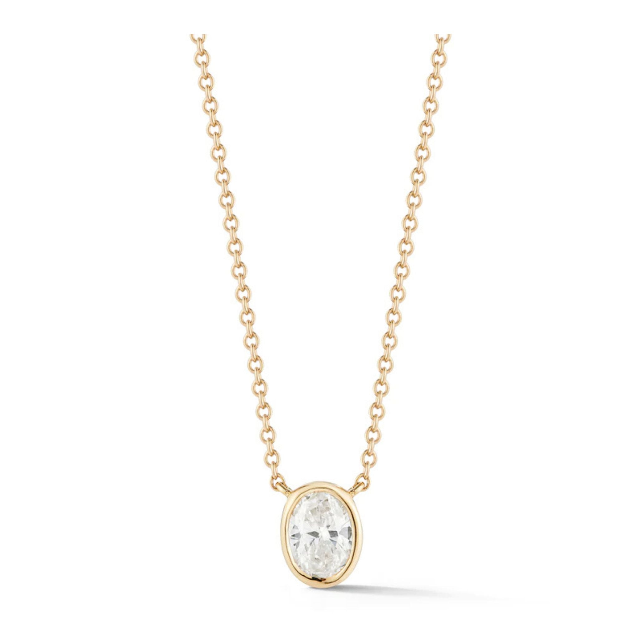 Bezel Set Oval Diamond Solitaire Pendant in Yellow Gold, featuring an adjustable 18k yellow gold chain and a clear oval-shaped diamond set in a simple gold bezel.