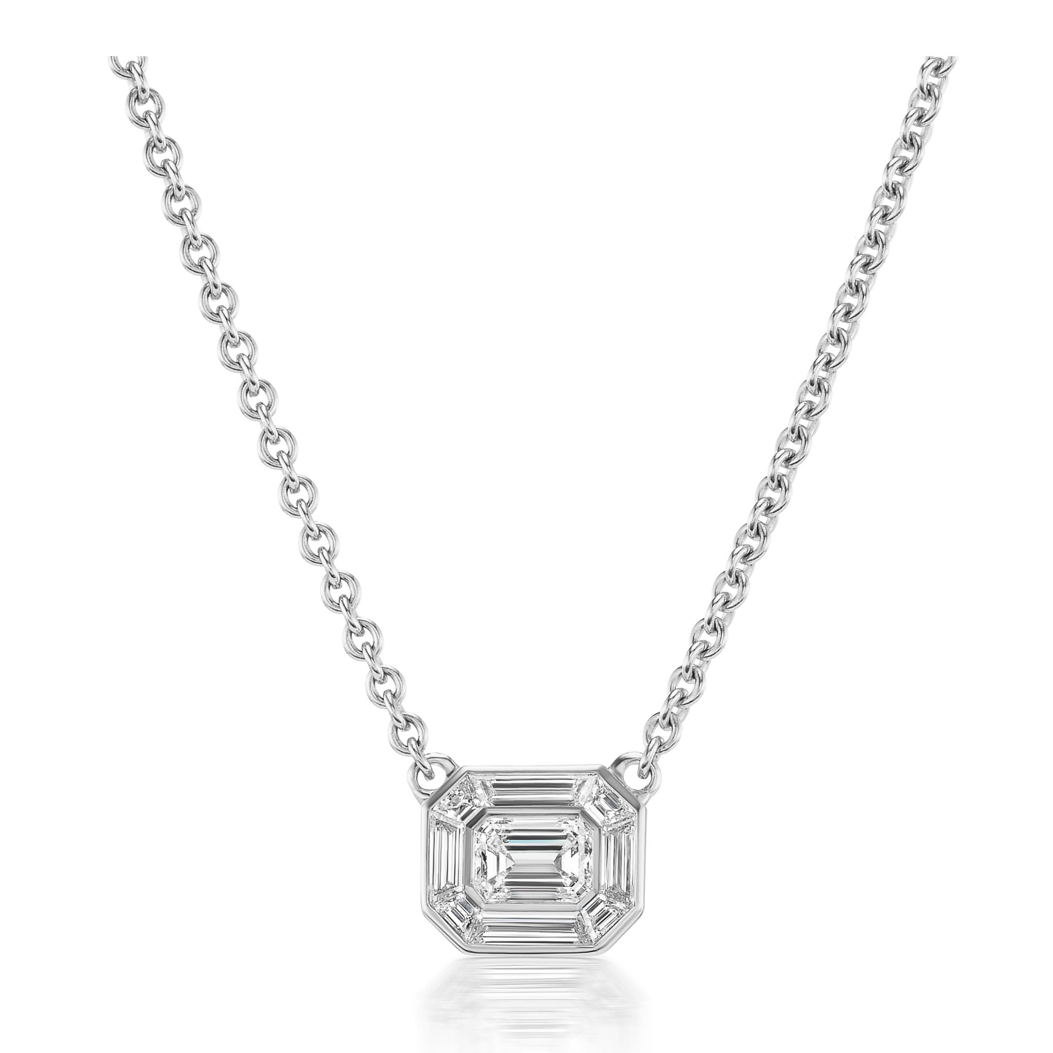 Introducing the Emerald Cut Mosaic Pendant in White Gold—a silver chain necklace showcasing a geometric, square-shaped pendant with beveled edges and a clear, emerald-cut-inspired faceted gemstone at its center, elegantly set against a white background.