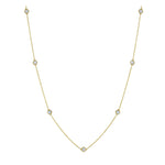 The Large Serpentine Station Necklace features seven round white diamonds, each set in a striking hexagon bezel along an 18K gold chain. This station necklace showcases a refined and modern design, elegantly displayed against a white background.
