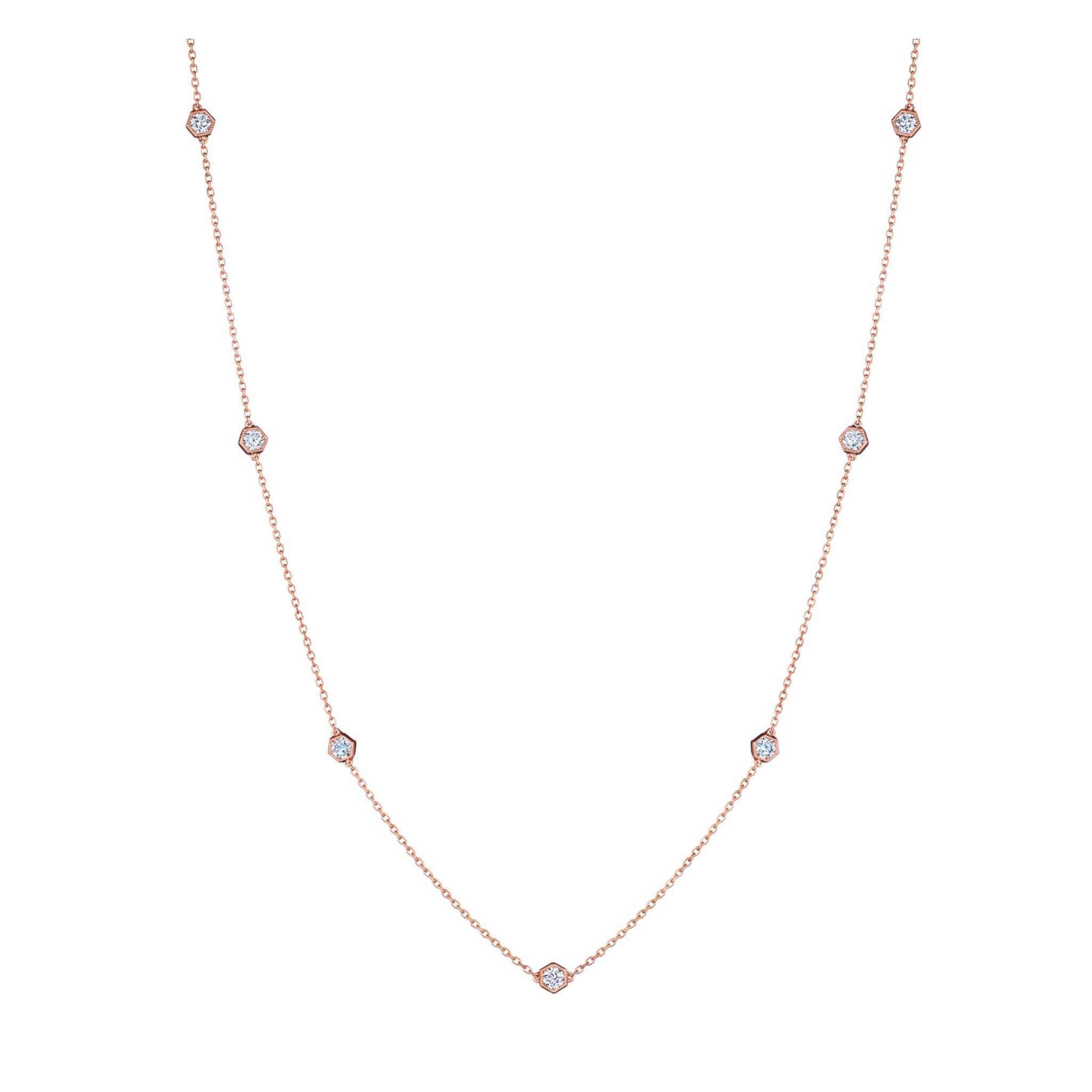 The Medium Serpentine Station Necklace With Hexagon Bezel Set Diamonds features a fine 18K rose gold chain adorned with evenly spaced, round diamonds, each elegantly set in hexagonal bezels and showcased against a white background.