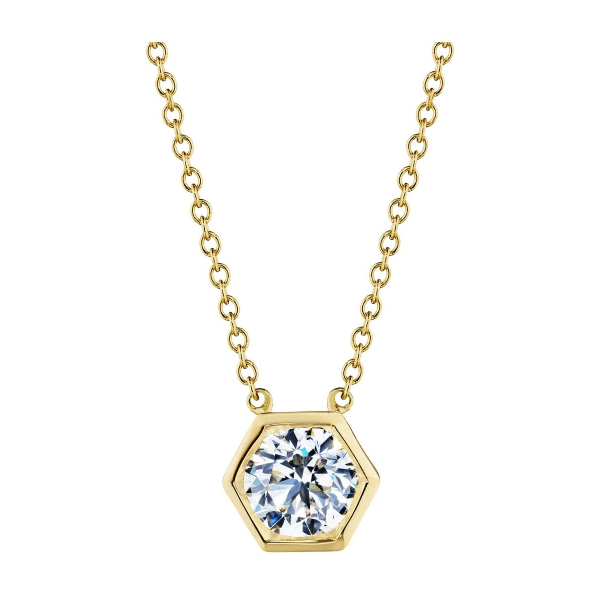 The Hexagon Bezel Set Round Brilliant Diamond Pendant is an 18k gold chain necklace featuring a hexagon-shaped pendant with a bezel set round, brilliant diamond at its center.