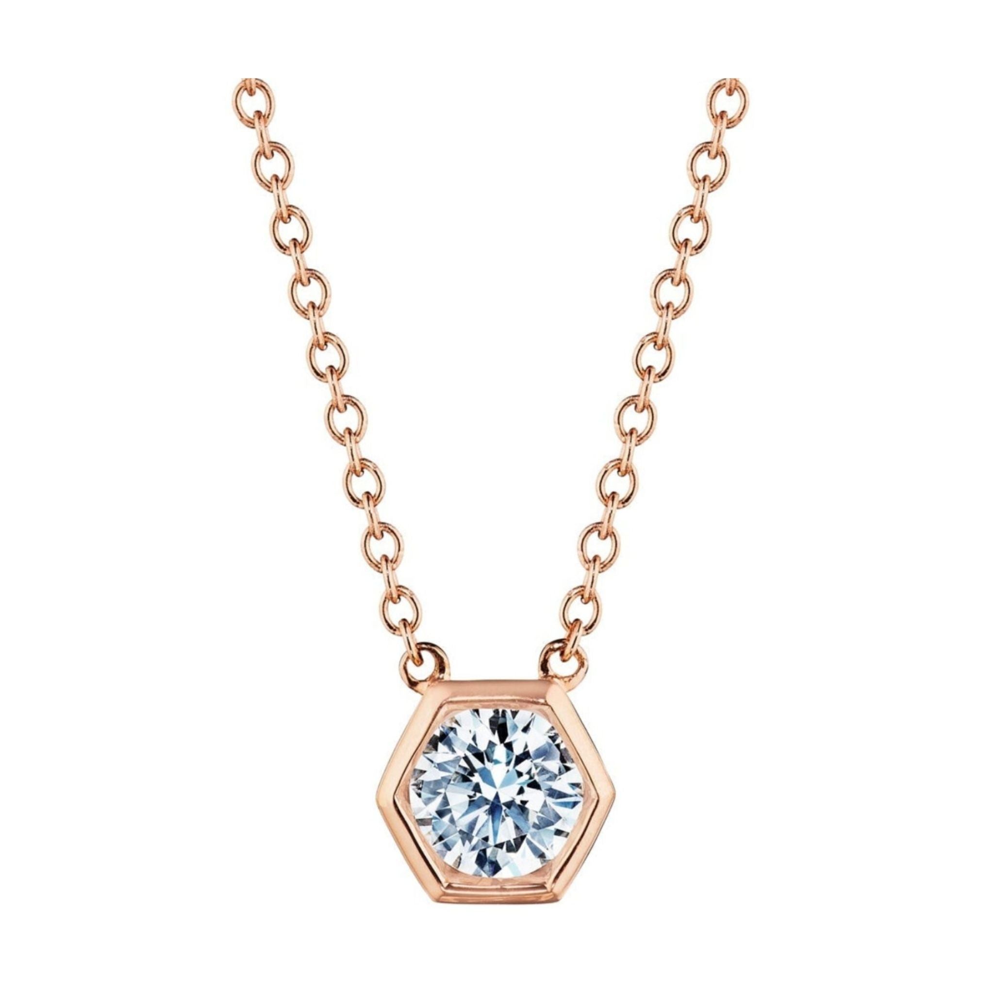 Introducing the Hexagon Bezel Set Round Brilliant Diamond Pendant: a stunning rose gold necklace showcasing a hexagonal pendant with a round, clear diamond bezel set at its center. Beautifully presented against a white background, this elegant 18k gold diamond necklace brings a modern flair to any jewelry collection.