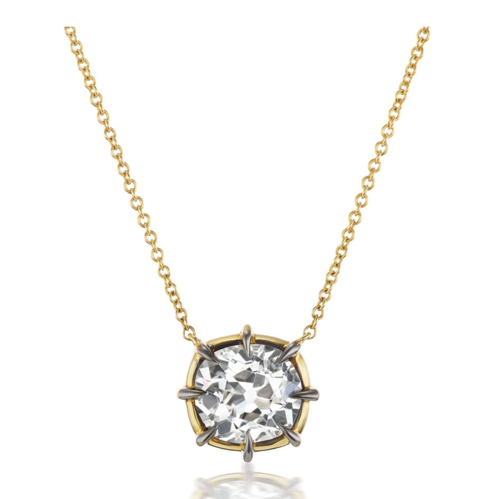 Introducing the Cushion Cut Diamond Collet Pendant in Yellow and Blackened Gold—a gold chain necklace showcasing a round cushion cut diamond solitaire pendant. The classic and elegant design is beautifully crafted in 18k yellow and blackened gold, enhancing the brilliance of the gemstone with a timeless collet setting.