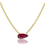 Introducing the East-West Pear Ruby Solitaire Pendant in Yellow Gold—a stunning gold chain necklace showcasing a pear-shaped ruby solitaire, elegantly set in 18K yellow gold.